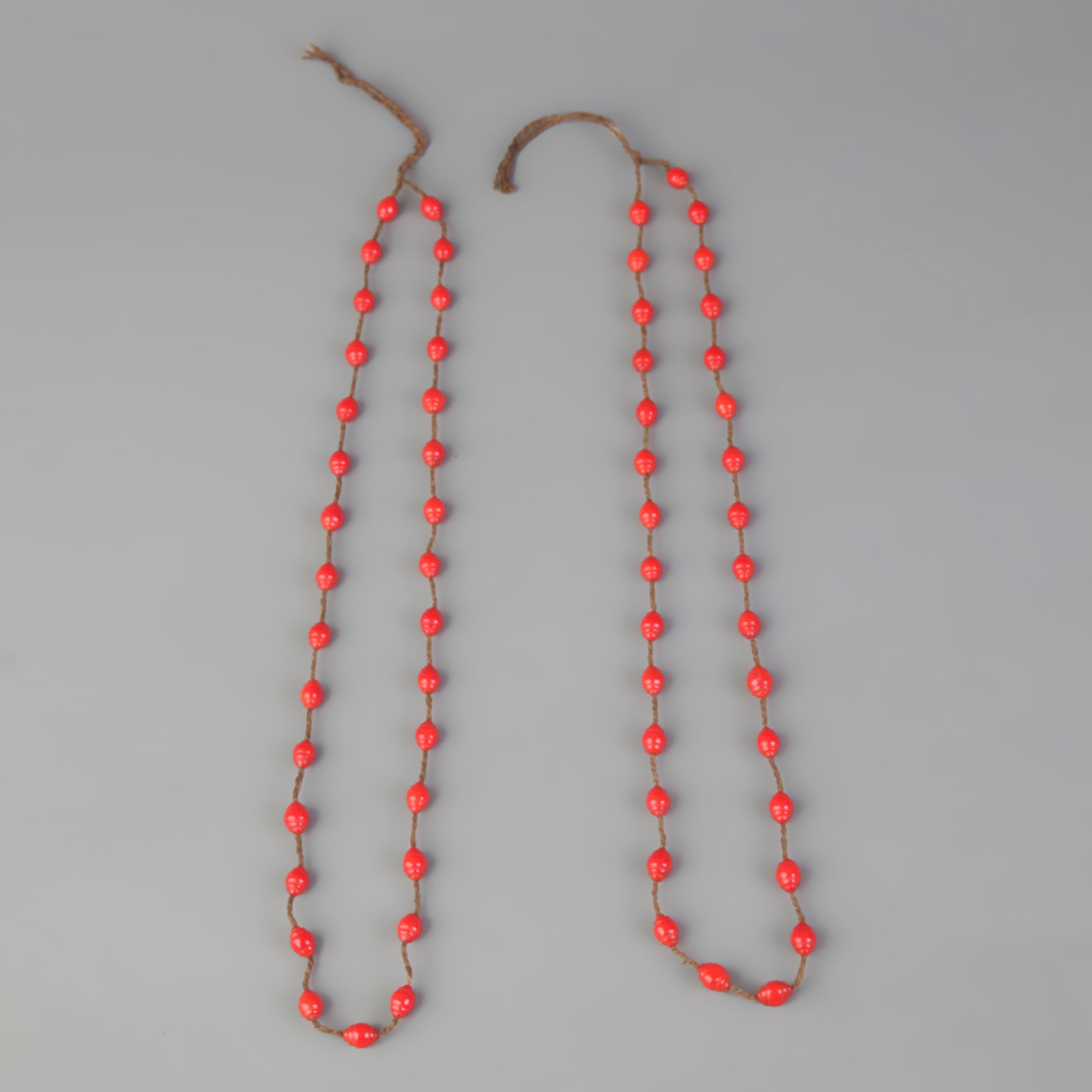 GROUP OF TWO RED CORAL NECKLACE: Modern; Long: 11.5 inch; Diameter: 0.2 inch. Wooden base for picture and display only.