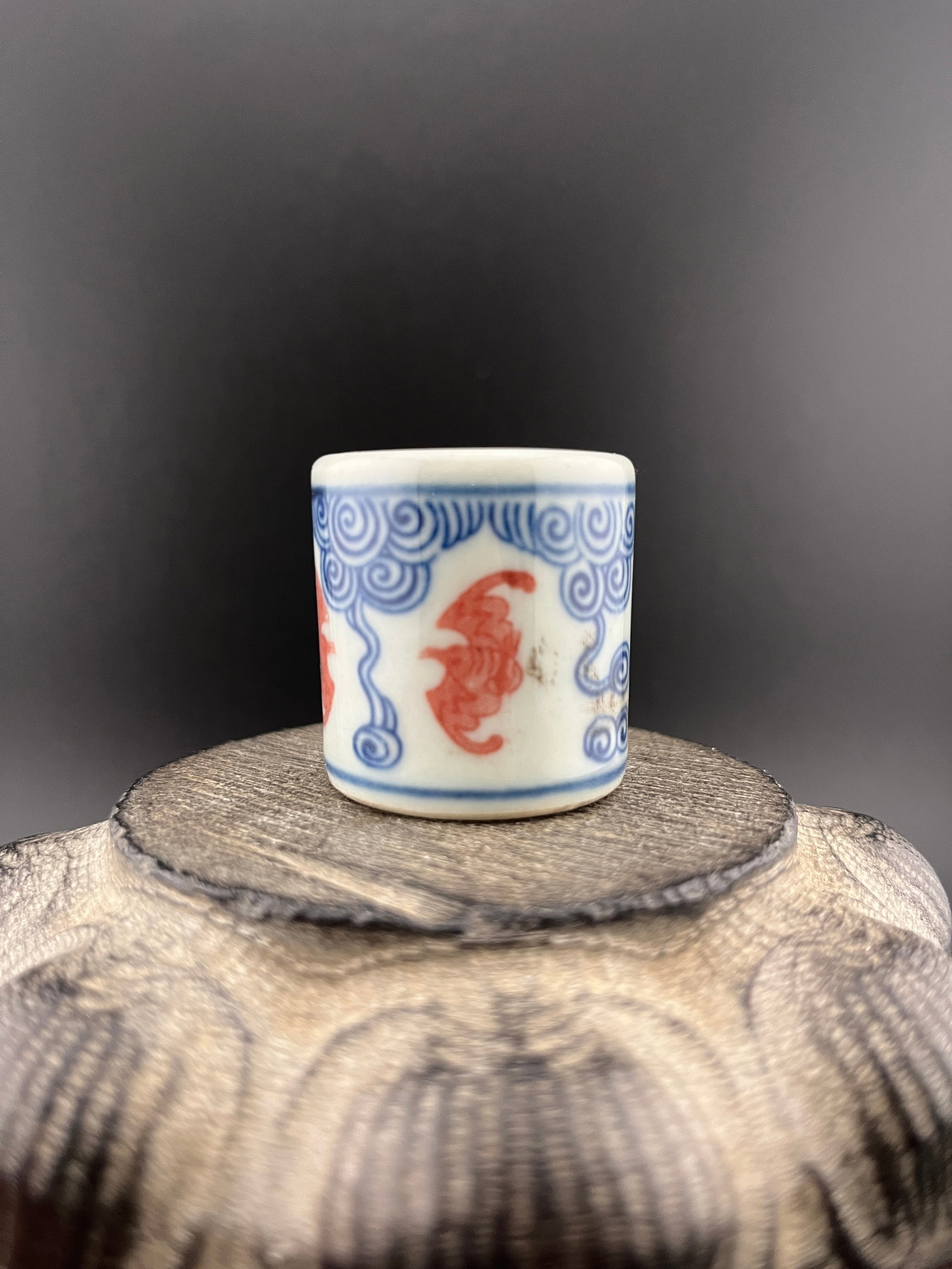 A FINE BAT PATTERN PORCELAIN THUMB RING: Republic Period; High: 1.4 inch; Diameter: 1.3 inch. Wooden base for picture and display only.