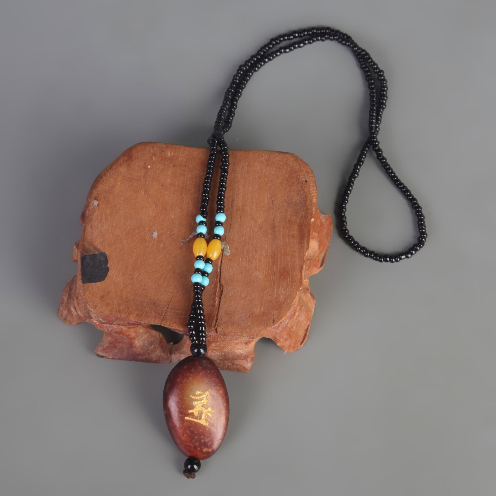 A FINE TIBETAN BUDDHIST AMULET PENDANT WITH BUDDHIST SCRIPTURE: Modern; Long: 1.5 inch; Width: 1.0 inch; Wooden base for picture and display only.