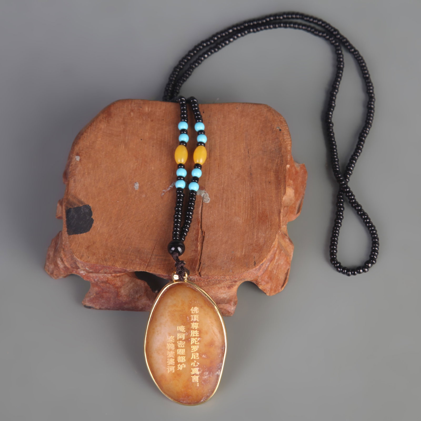 A FINE TIBETAN BUDDHIST AMULET PENDANT WITH BUDDHIST SCRIPTURE: Modern; Long: 1.9 inch; Width: 1.3 inch. Wooden base for picture and display only.