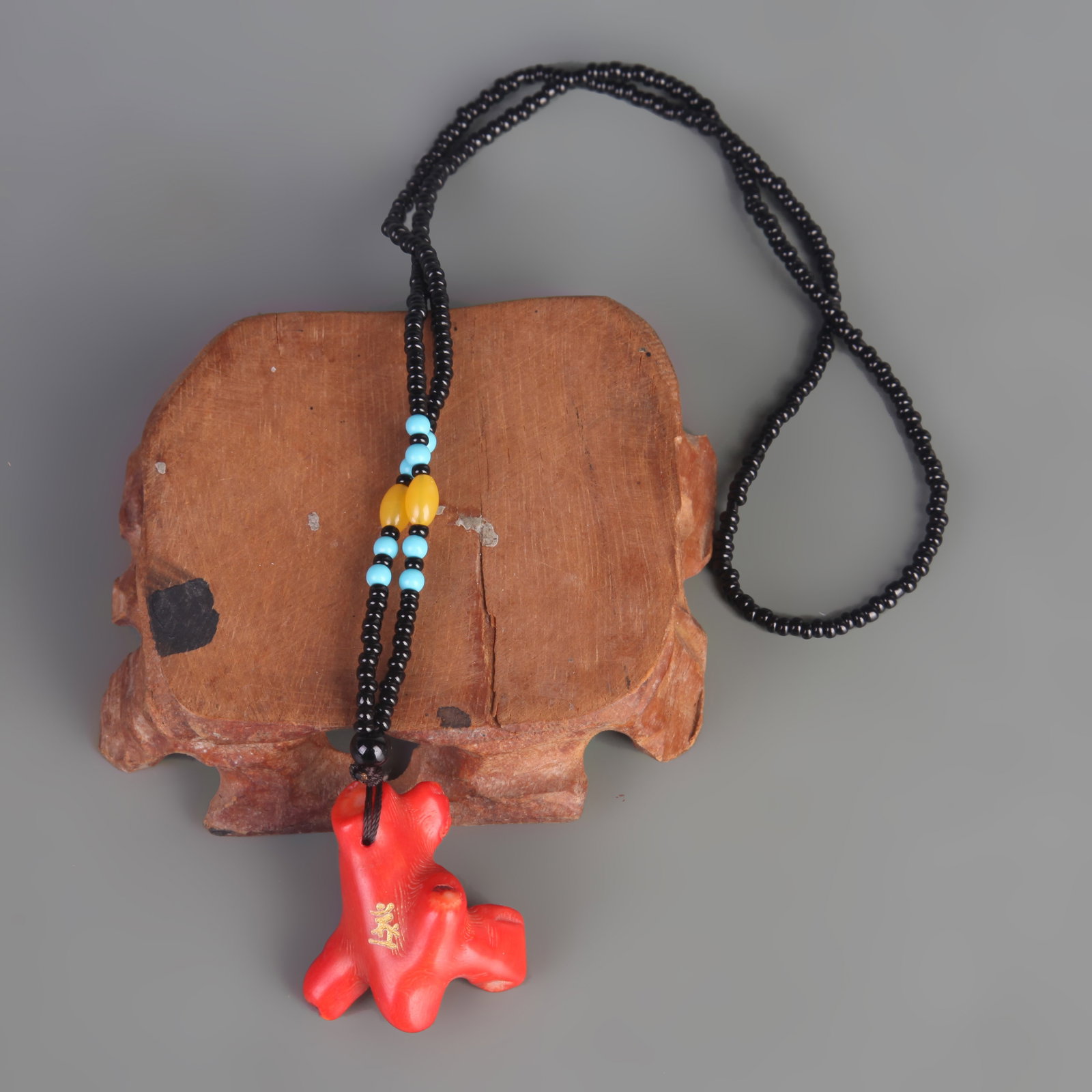 A FINE CORAL NECKLACE: Modern; Long: 1.5 inch; Width: 1.4 inch; Wooden base for picture and display only.