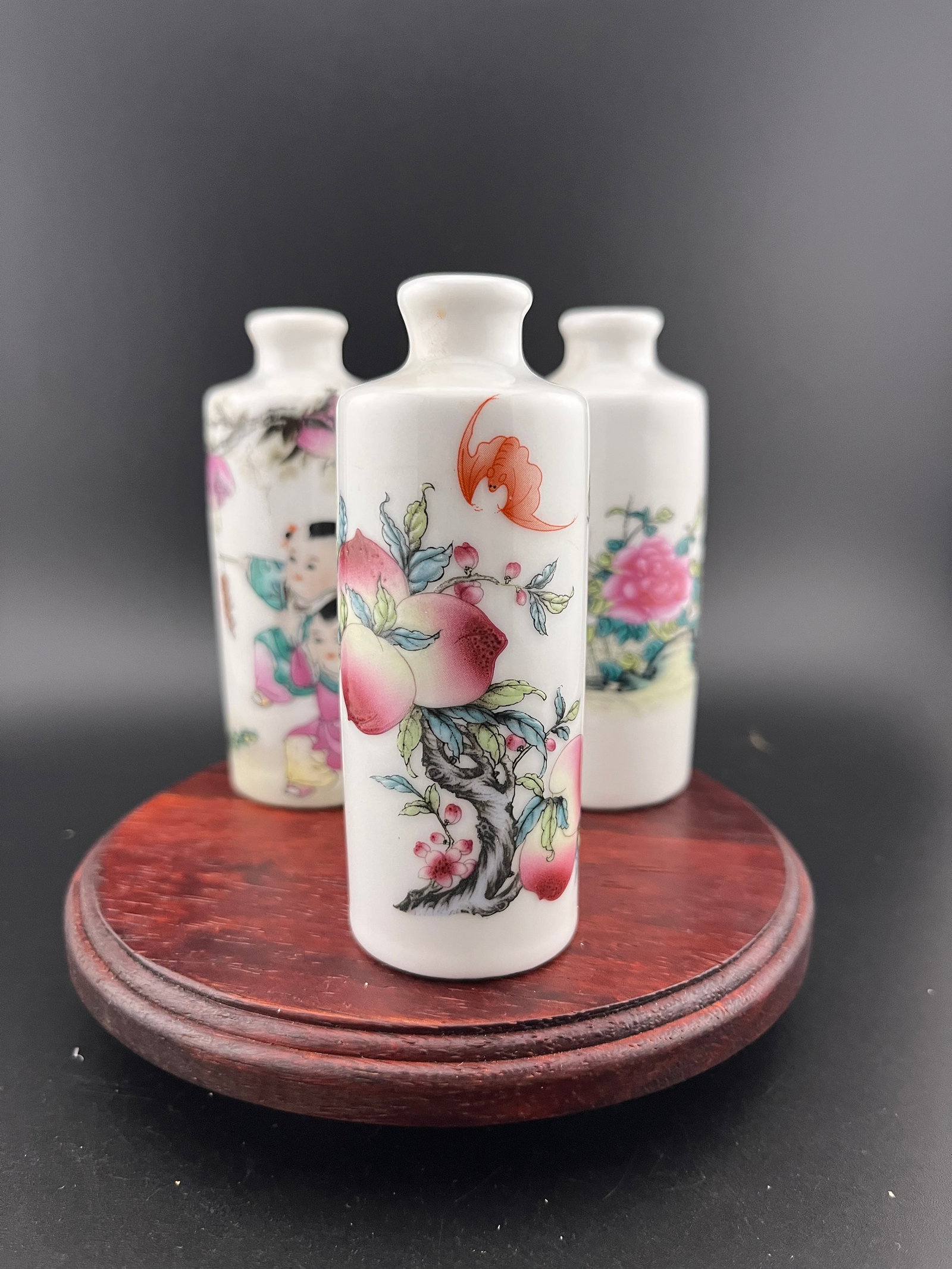 GROUP OF THREE FAMILLE ROSE PORCELAIN SNUFF BOTTLE: Modern; High: 3.73 inch; Diameter: 1.42 inch. High: 3.74 inch; Diameter: 1.42 inch. High: 3.7 inch; Diameter: 1.42 inch. Wooden base for picture and display only.