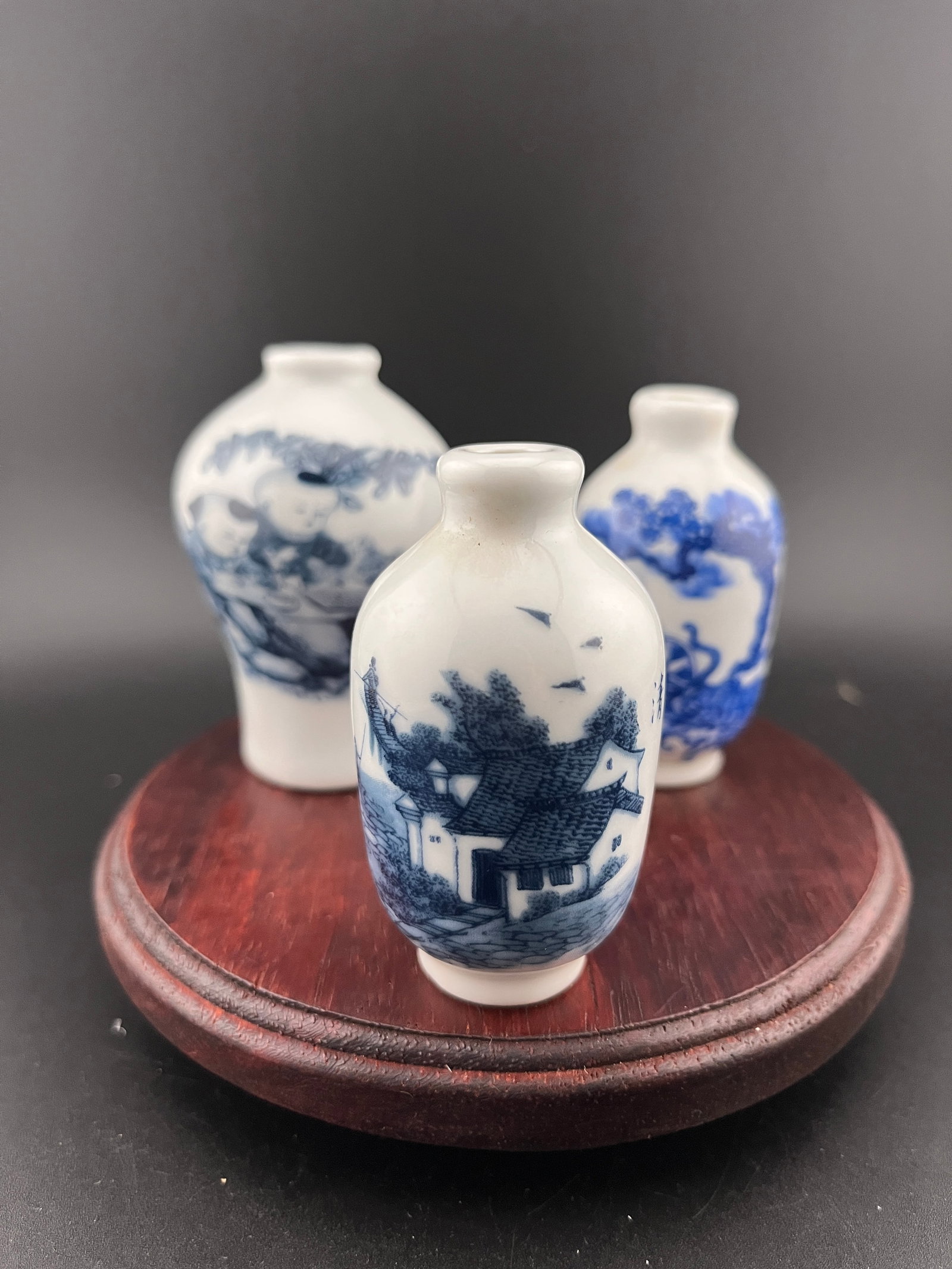 GROUP OF THREE FAMILLE ROSE PORCELAIN SNUFF BOTTLE: Modern; High: 2.6 inch; Diameter: 1.42 inch; High: 2.6 inch; Diameter: 1.42 inch; High: 2.88 inch; Diameter: 1.88 inch. Wooden base for picture and display only.