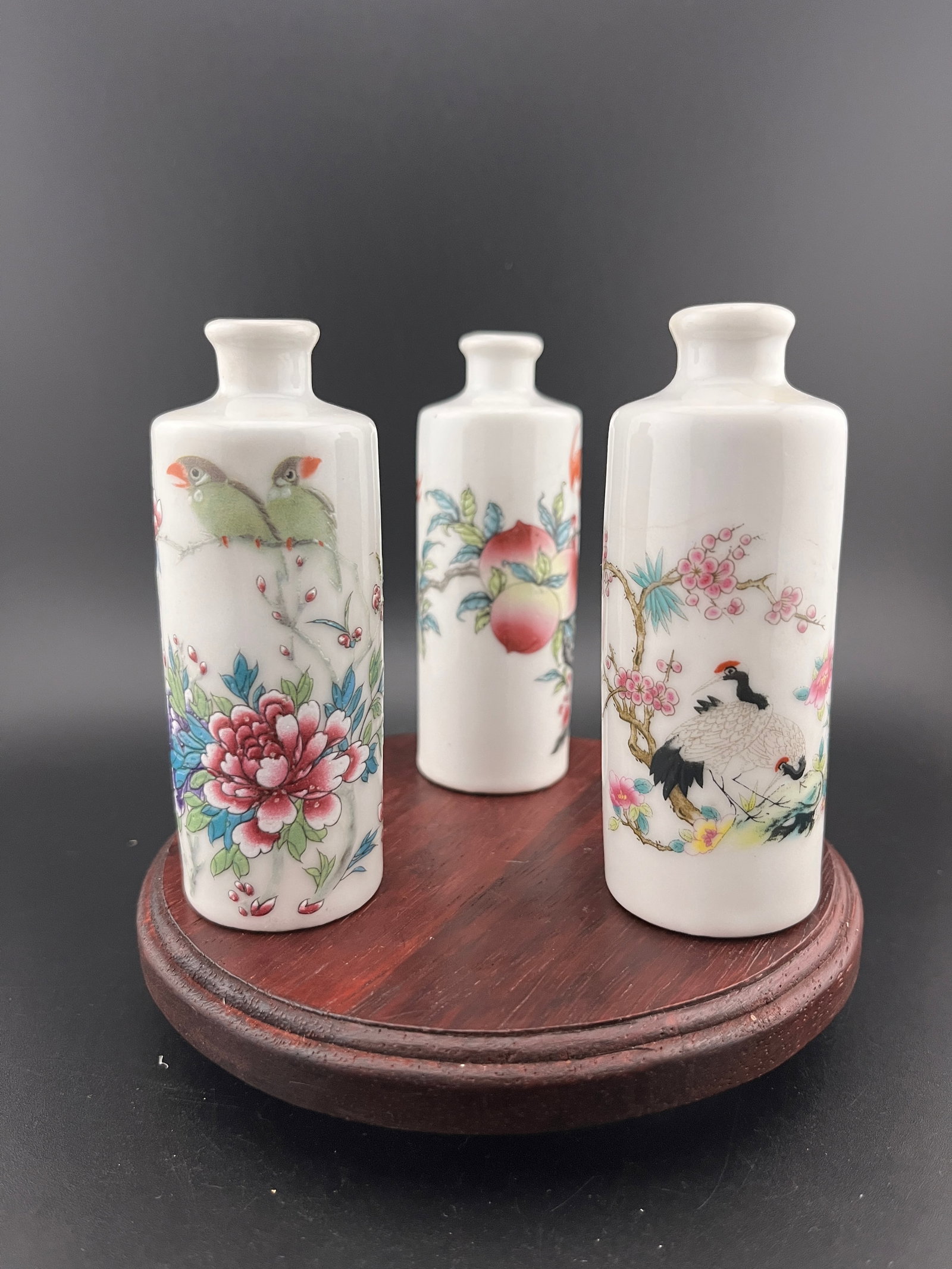 GROUP OF THREE FAMILLE ROSE PORCELAIN SNUFF BOTTLE: Modern; High: 3.8 inch; Diameter: 1.4 inch. Wooden base for picture and display only.