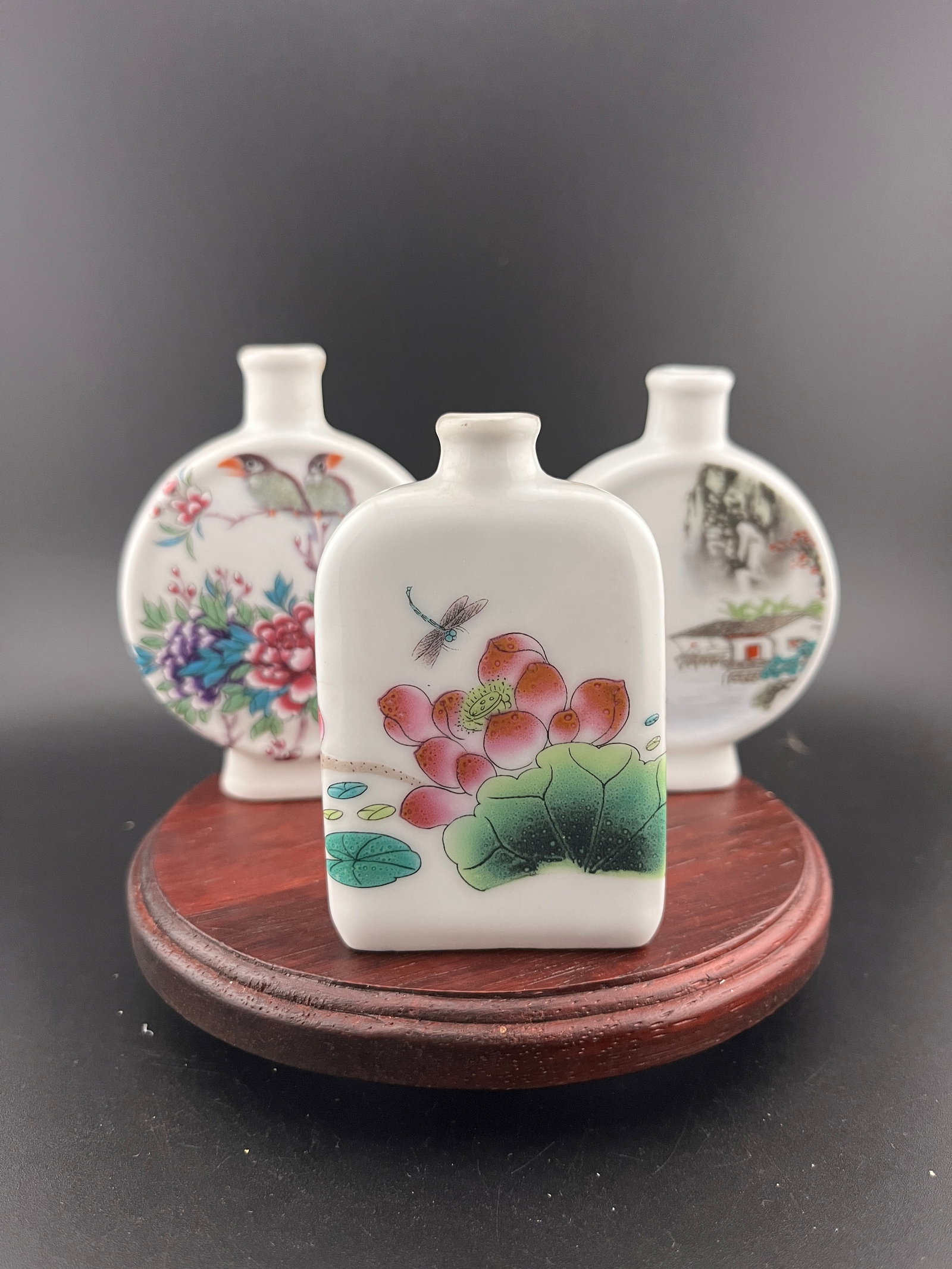 GROUP OF THREE FAMILLE ROSE PORCELAIN SNUFF BOTTLE: Modern; Long: 2.6 inch; Width: 0.84 inch; High: 3.53 inch; Long: 2.6 inch; Width: 0.74 inch; High: 3.4 inch; Long: 2 inch; Width: 0.8 inch; High: 3.1 inch. Wooden base for picture and display only.