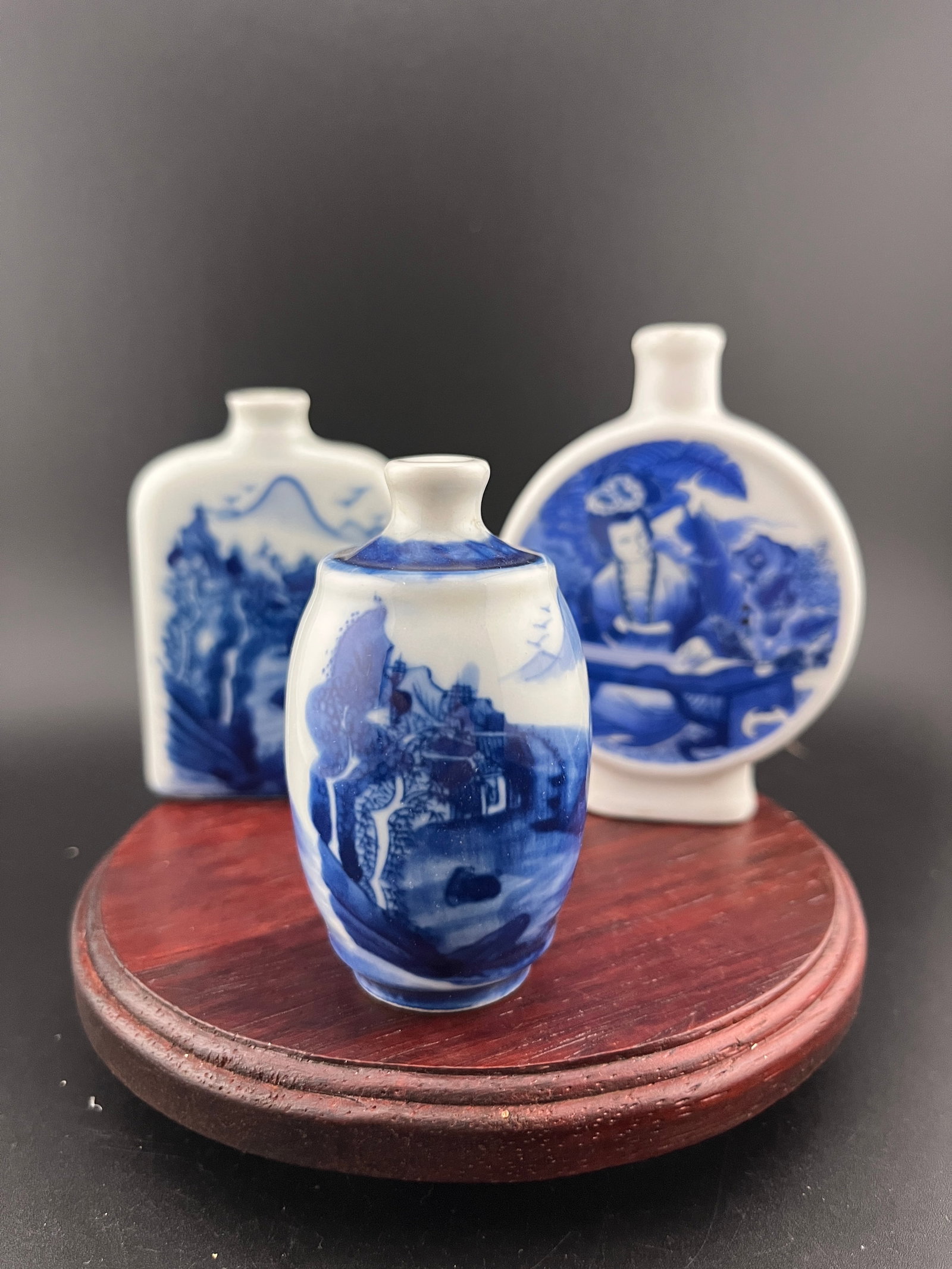 GROUP OF THREE FAMILLE ROSE PORCELAIN SNUFF BOTTLE: Modern; High: 2.8 inch; Diameter: 1.6 inch; Long: 2 inch; Width: 0.75 inch; High: 3.02 inch; Long: 2.6 inch; Width: 0.77 inch; High: 3.5 inch. Wooden base for picture and display only.