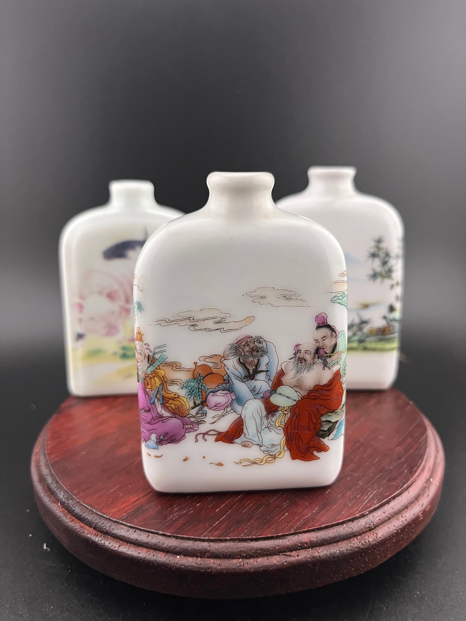 GROUP OF THREE FAMILLE ROSE PORCELAIN SNUFF BOTTLE: Modern; Long: 2.1 inch; Width: 0.84 inch; High: 3.1 inch; Long: 2.1 inch; Width: 0.84 inch; High: 3.1 inch; Long: 1.93 inch; Width: 0.7 inch; High: 2.93 inch. Wooden base for picture and display only.