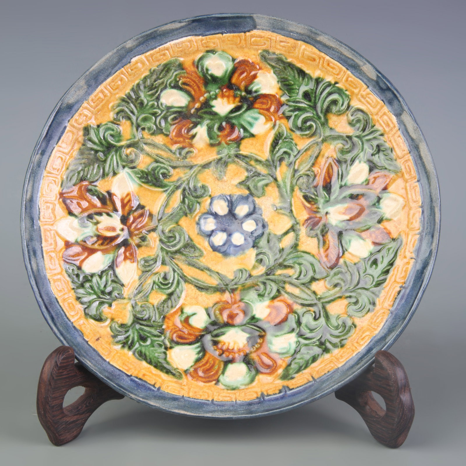 A SANCAI DISH WITH FLORAL DECORATION: Tang Dynasty Style; Diameter: 6.5 inch; Wooden base for picture and display only.