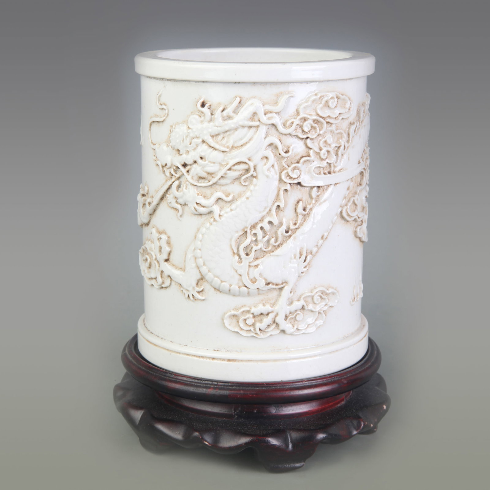 WHITE PORCELAIN BRUSH POT CARVED WITH DRAGON PATTERNS: Qing Dynasty Wang Bing Rong Mark; Diameter: 4.3 inch; High: 5.5 inch; Wooden base for picture and display only.