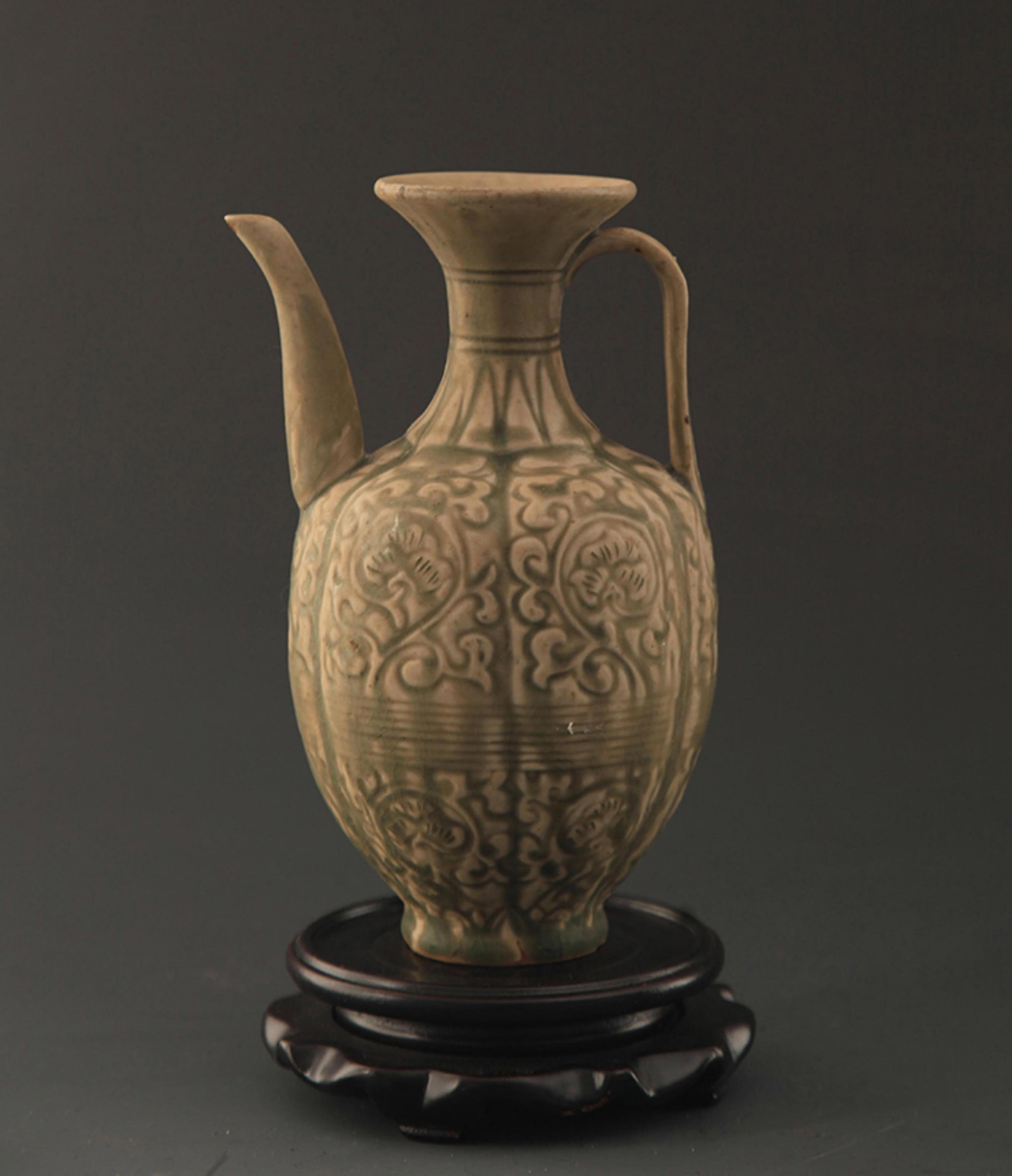 A LONG QUAN KILN FLOWER CARVING EWER: Yuan Dynasty Style; High: 7.5 inch; Width: 4.0 inch; Diameter: 2.5 inch. Wooden base for picture and display only.