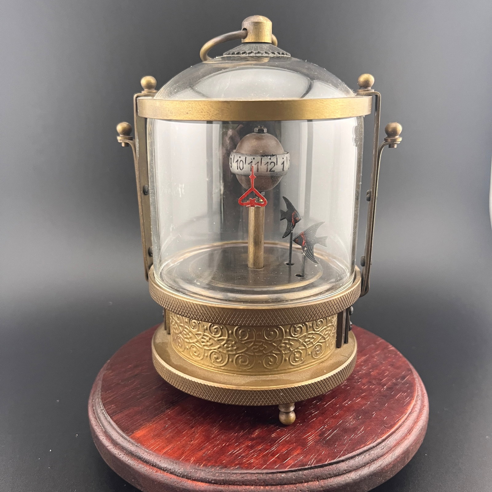 A FINE SMALL FISH TANK STYLE TABLE CLOCK: 20th Century; High: 5.4 inch; Diameter: 3.15 inch. Wooden base for picture and display only.