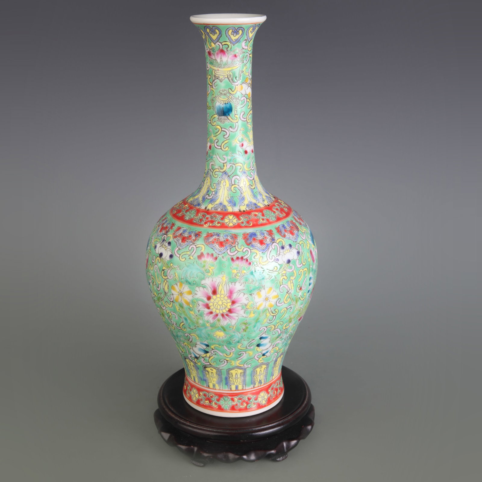 A FAMILLE ROSE GREEN-GROUND LONG-NECK VASE WITH FLORAL DECORATION: Qing Dynasty; Diameter: 3.2 inch; High: 11.6 inch; Wooden base for picture and display only.