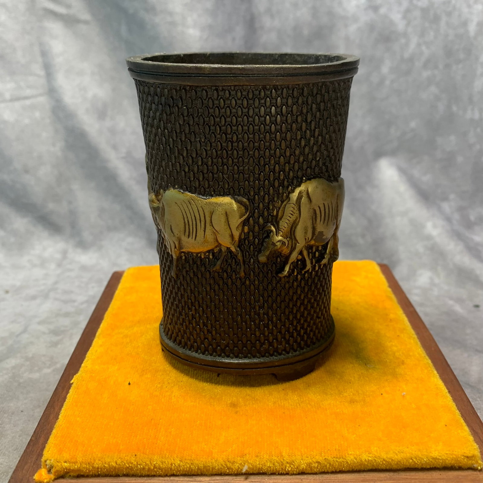 A QIAN LONG MARKED BRONZE BRUSH POT DECORATED WITH FOUR OXEN: Qing Dynasty; Long: 3.2 inch; High: 4.6 inch. Wooden base for picture and display only.