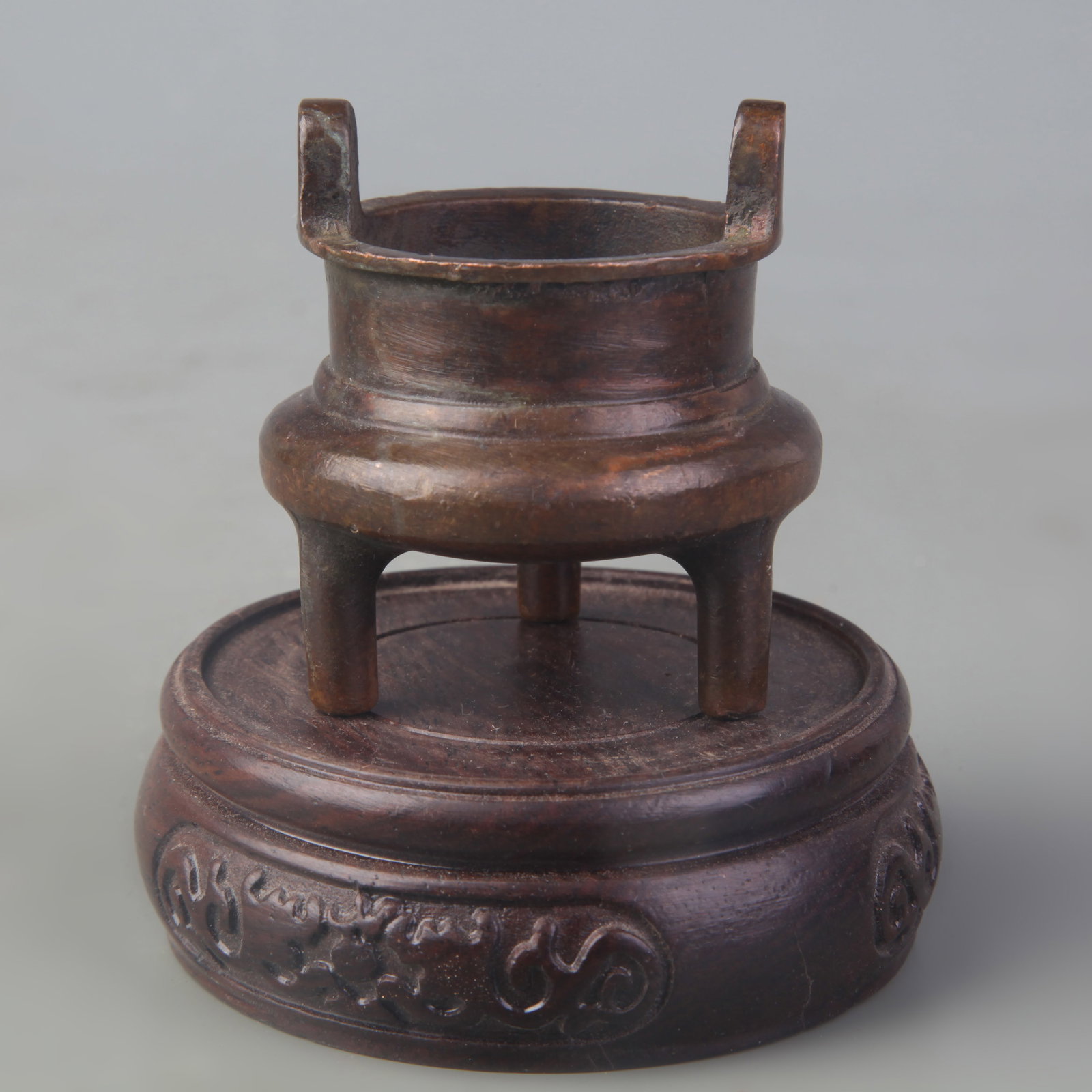 A SMALL TRIPOD CENSER WITH UPRIGHT HANDLES: Qing Dynasty; High: 2.1 inch; Wooden base for picture and display only.