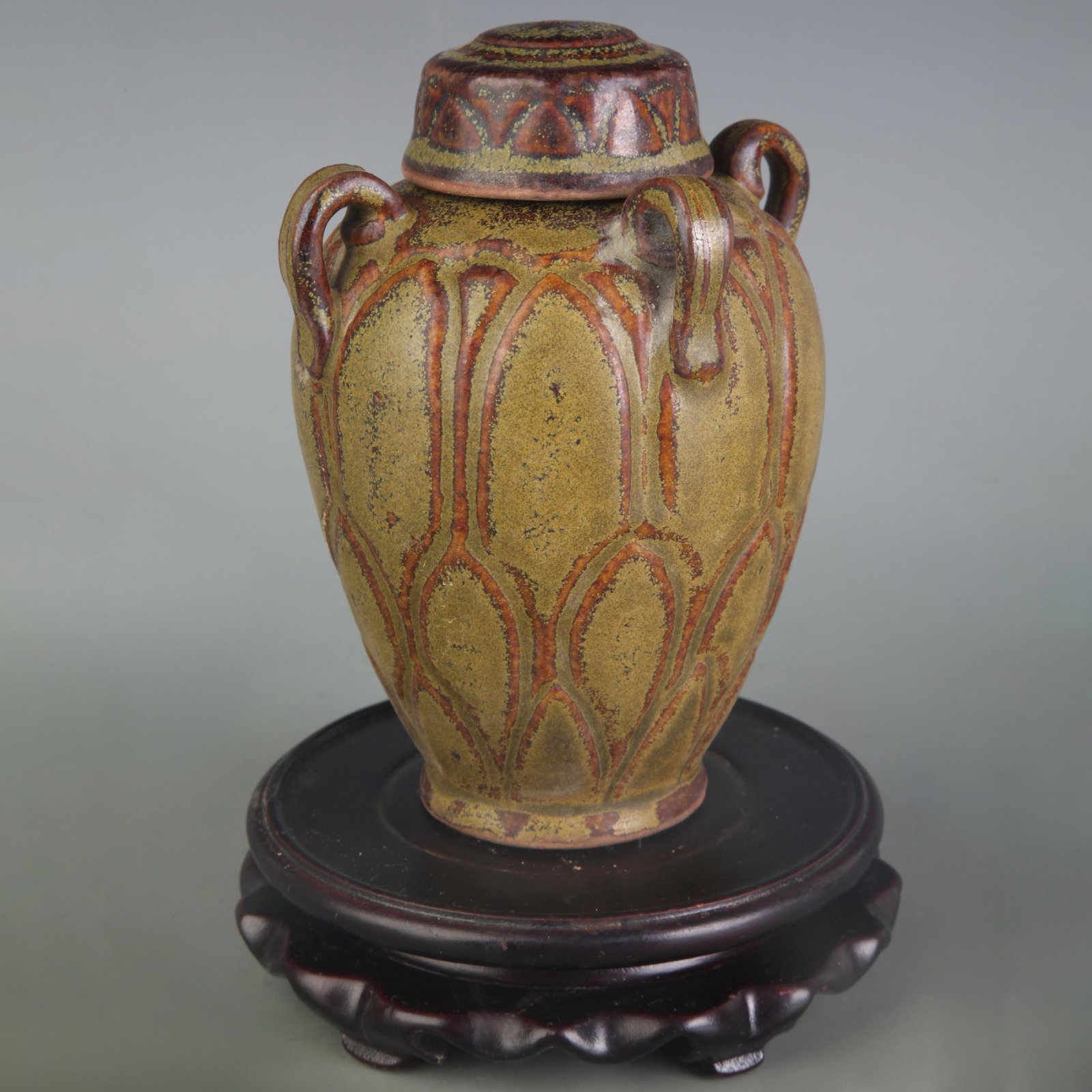 AN EEL-YELLOW GLAZED JAR WITH FOUR LOOP HANDLES: Qing Dynasty; High: 5.9 inch; Diameter: 2.2 inch; Wooden base for picture and display only.