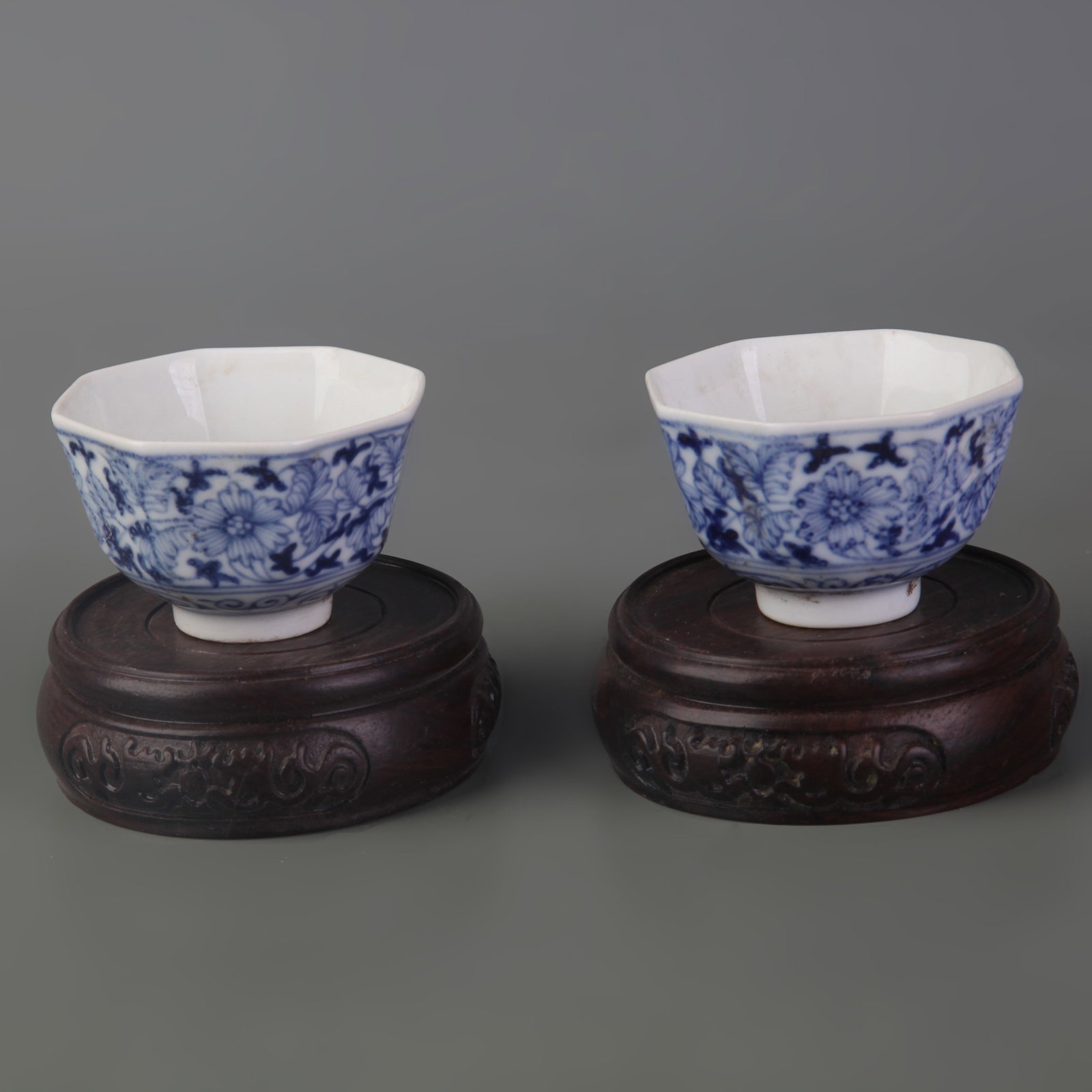 PAIR OF BLUE AND WHITE FLORAL DESIGN SMALL PORCELAIN BOWLS: Qing Dynasty; Diameter: 2.4 inch; High: 1.5 inch. Wooden base for picture and display only.