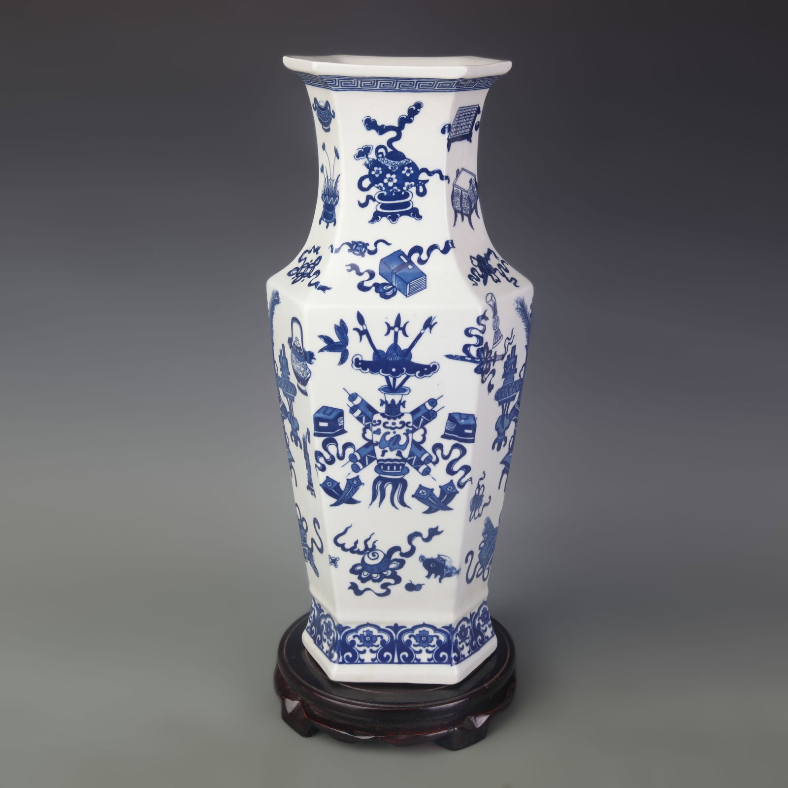 BLUE-AND-WHITE EIGHT-TREASURES HEXAGONAL PORCELAIN VASE: Qing Dynasty Qian Long Period; Width: 5.7 inch; High: 16.2 inch; Wooden base for picture and display only.