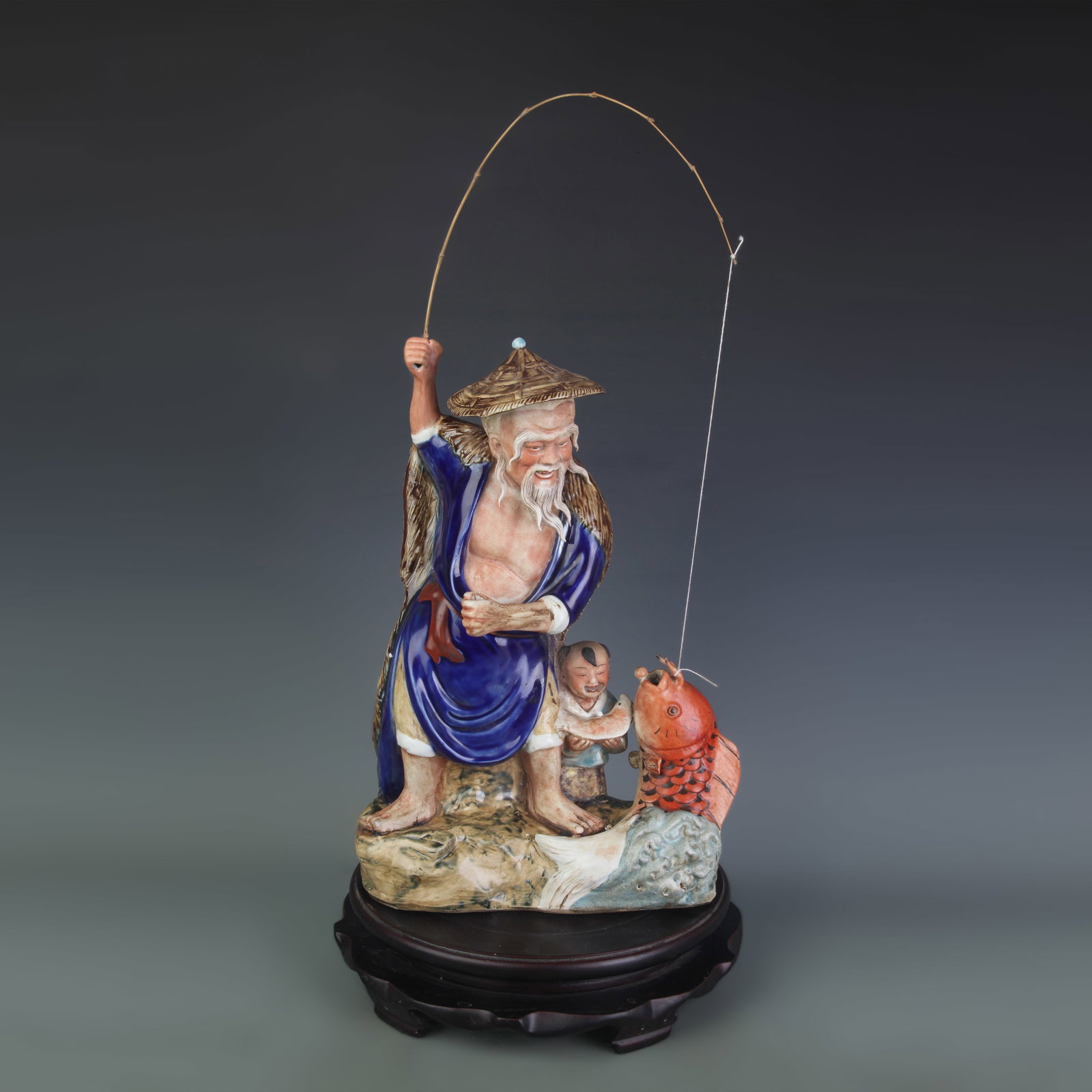 A FINE CERAMIC FISHERMAN ORNAMENT: Qing Dynasty; High: 14.8 inch; Width: 10.0 inch; Wooden base for picture and display only.