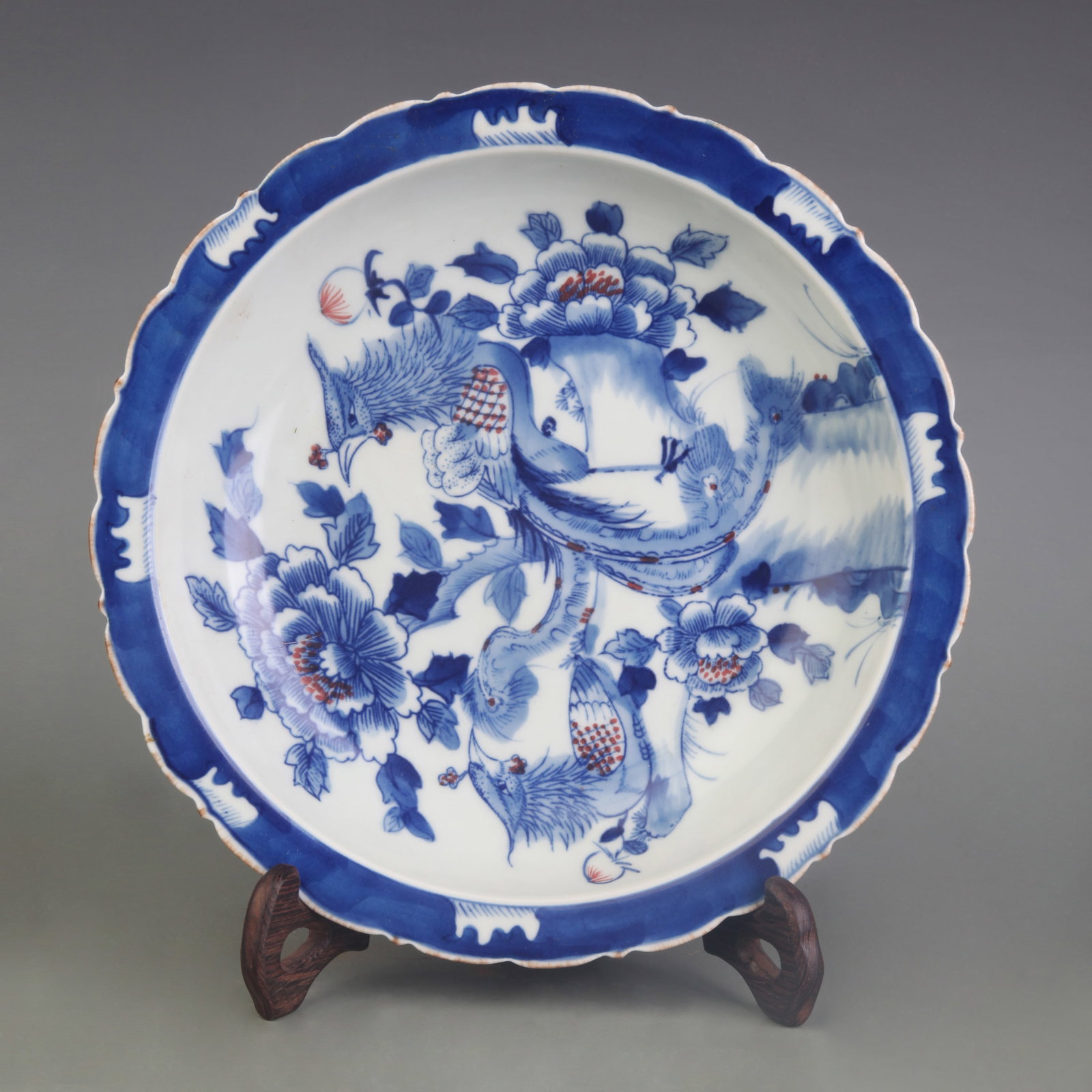A BLUE AND WHITE AND UNDERGLAZE RED DISH WITH BIRD-AND-FLOWER DECORATION: Qing Dynasty; Diameter: 8.6 inch; Wooden base for picture and display only.