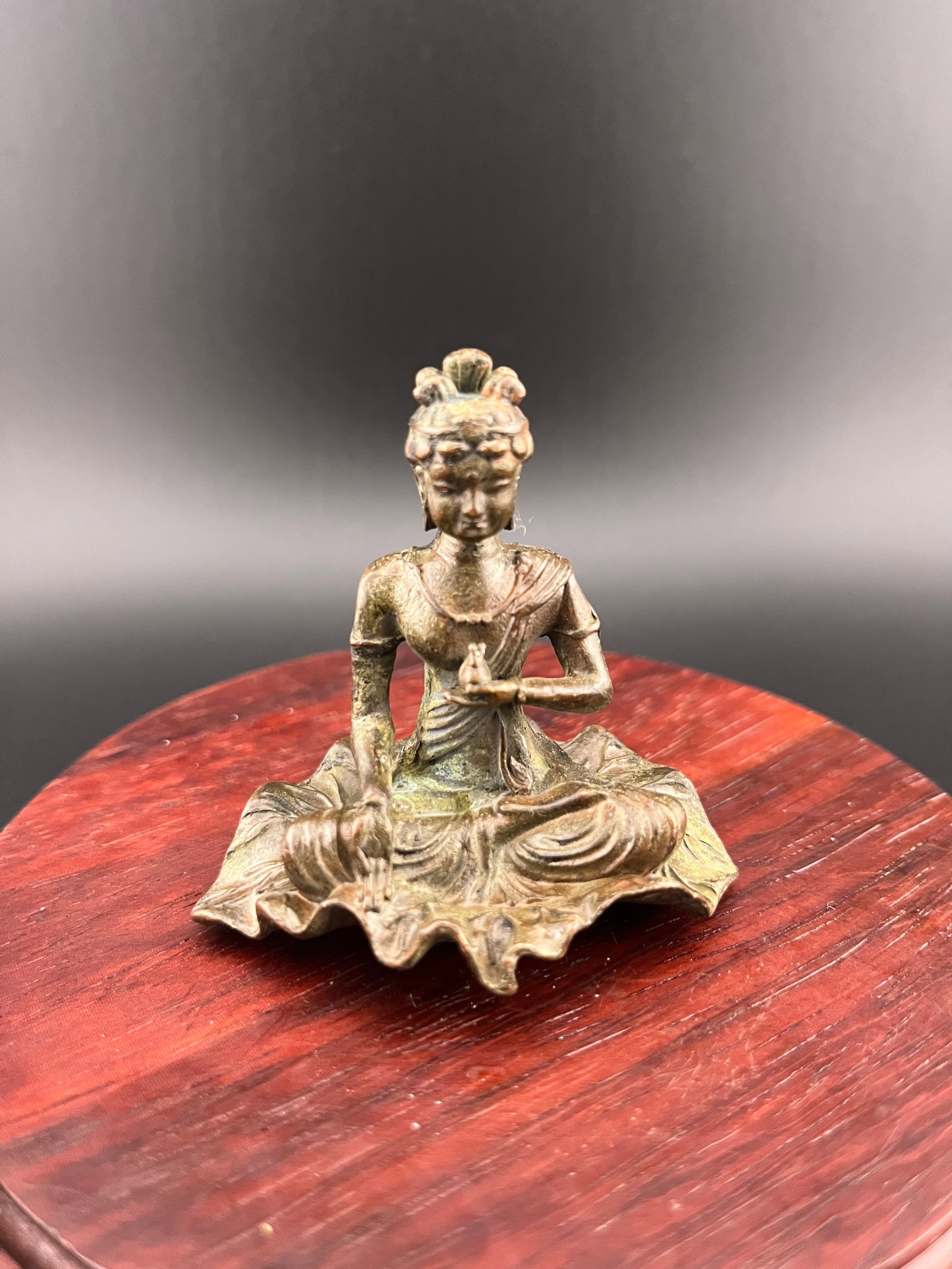 A SMALL BRONZE FIGURE OF GUANYIN ON LOTUS LEAF BASE: 20th Century; Long: 2.4 inch; Width: 1.8 inch; High: 2.4 inch. Wooden base for picture and display only.