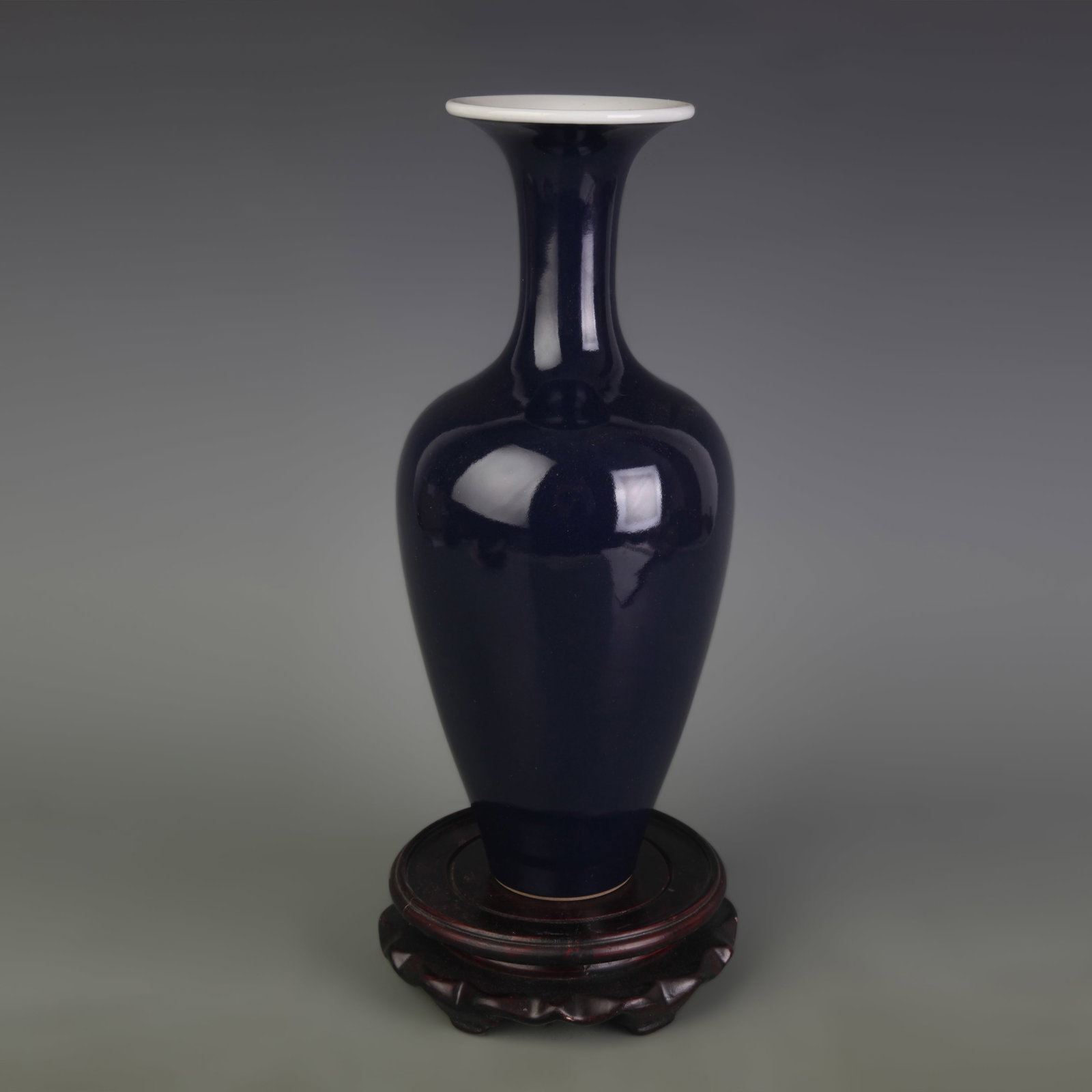 A FINE SACRIFICIAL BLUE GLAZED PORCELAIN VASE: Qing Dynasty; High: 10.8 inch; Diameter: 3.2 inch; Wooden base for picture and display only.