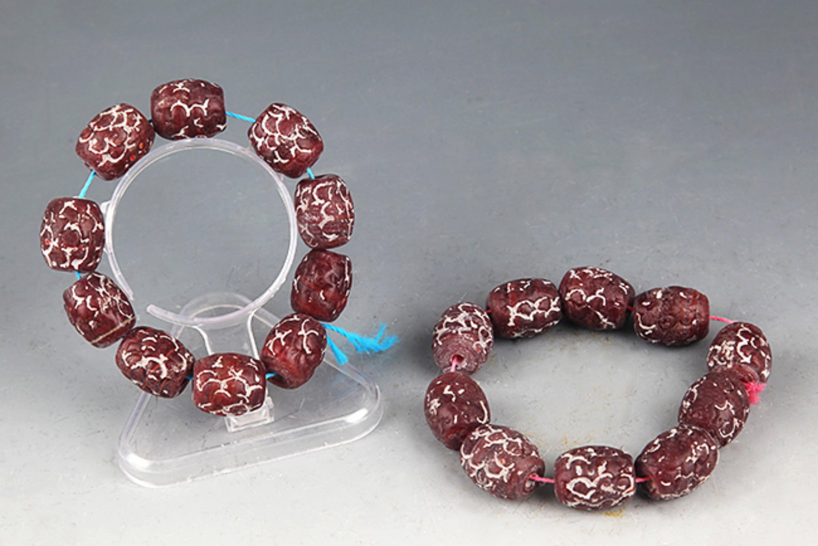 PAIR OF DARK RED COLOR GLASS MADE BRACELETS: Han Dynasty Style; Diameter: 0.75 inch. Wooden base for picture and display only.