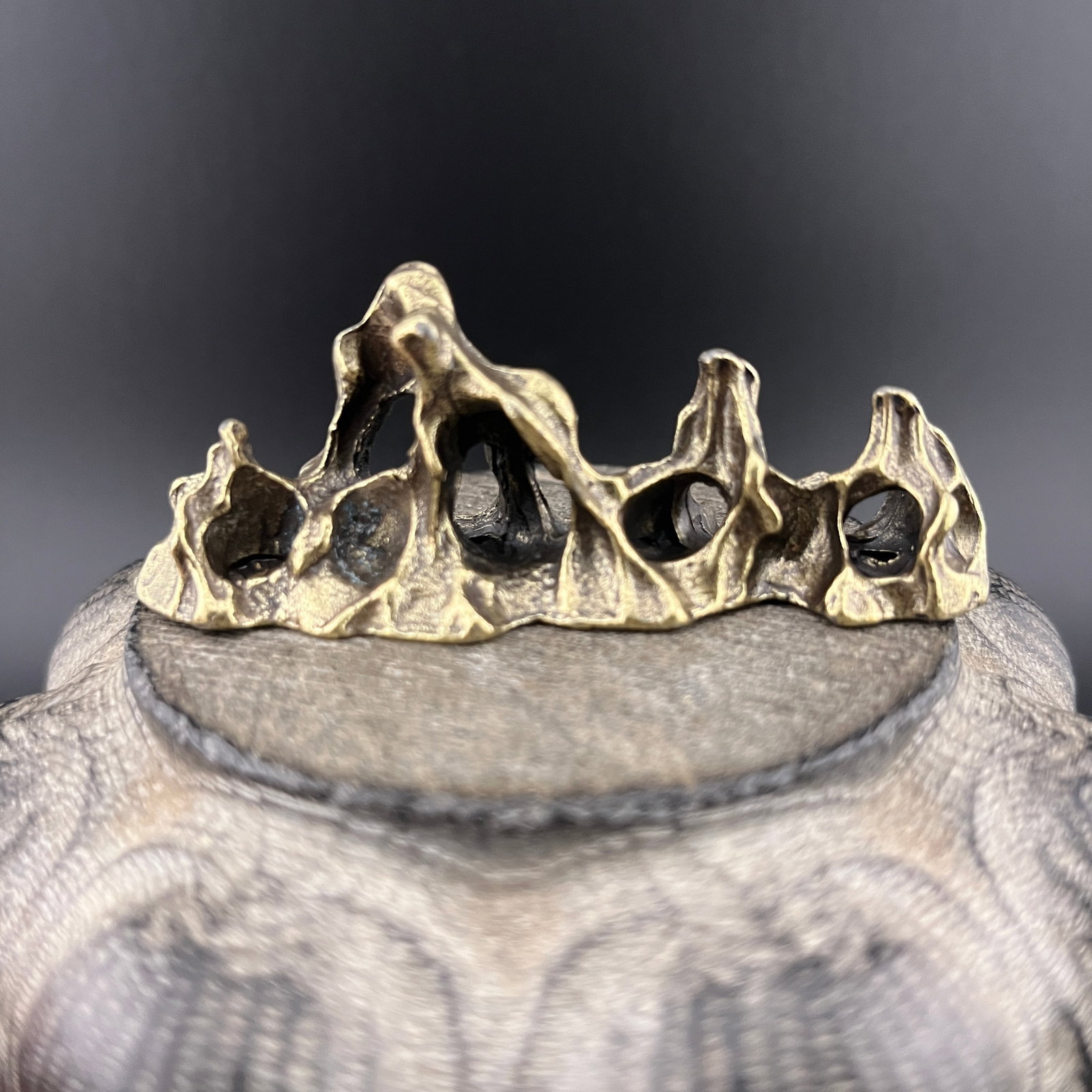A SMALL BRONZE MOUNTAIN FIGURE: Modern; Long: 3 inch; Width: 1 inch; High: 1.1 inch. Wooden base for picture and display only.