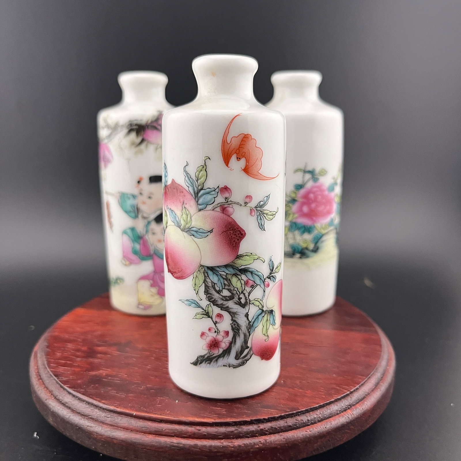 GROUP OF THREE FAMILLE ROSE PORCELAIN SNUFF BOTTLE: Modern; High: 3.73 inch; Diameter: 1.42 inch. High: 3.74 inch; Diameter: 1.42 inch. High: 3.7 inch; Diameter: 1.42 inch. Wooden base for picture and display only.