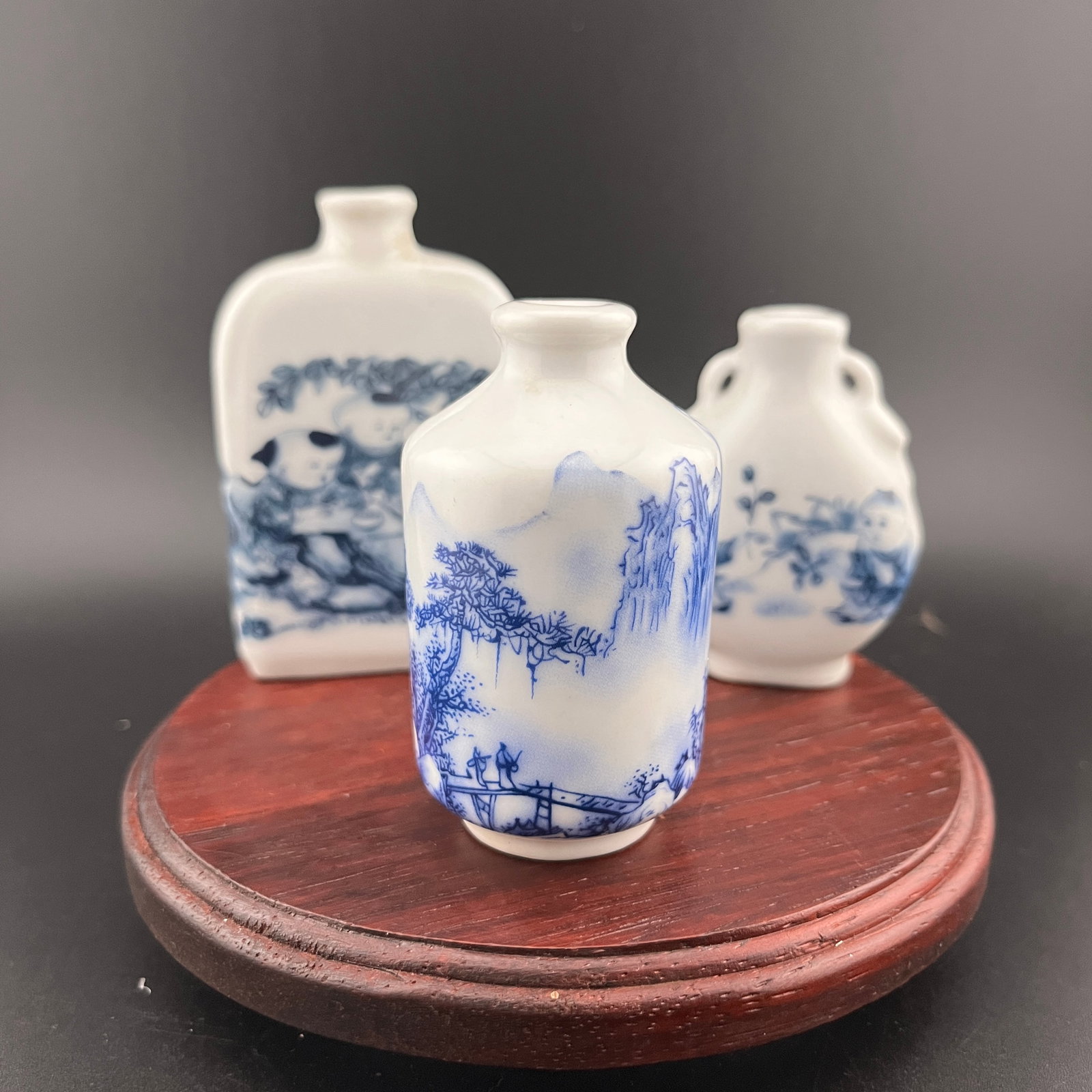 GROUP OF THREE FAMILLE ROSE PORCELAIN SNUFF BOTTLE: Modern; Long: 2.08 inch; Width: 0.8 inch; High: 3.2 inch; High: 2.7 inch; Diameter: 1.6 inch; Long: 1.78 inch; Width: 0.96 inch; High: 2.48 inch. Wooden base for picture and display only.