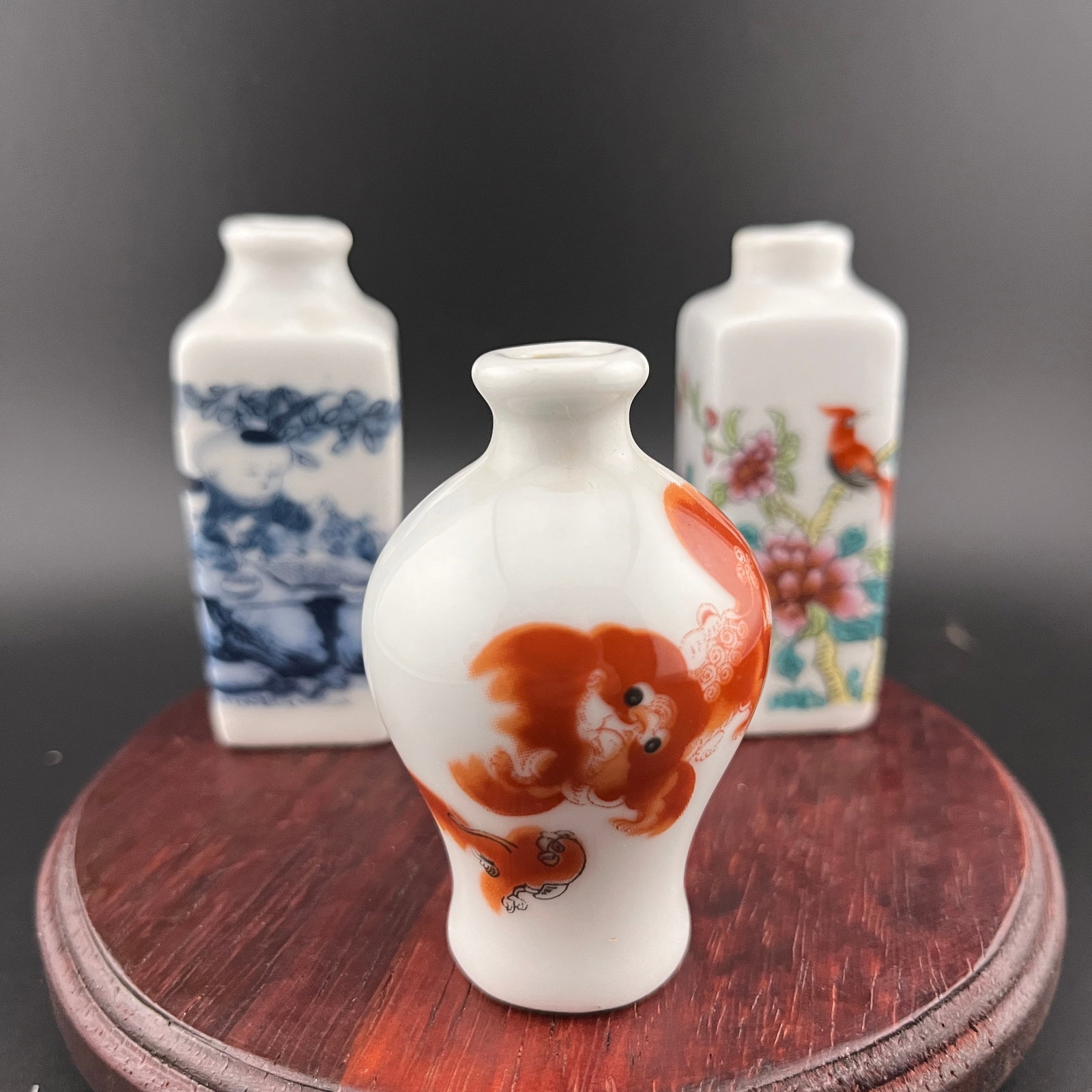 GROUP OF THREE FAMILLE ROSE PORCELAIN SNUFF BOTTLE: Modern; Long: 1.1 inch; Width: 1.1 inch; High: 2.8 inch; Long: 1.1 inch; Width: 1.1 inch; High: 2.8 inch; High: 2.5 inch; Diameter: 1.6 inch. Wooden base for picture and display only.