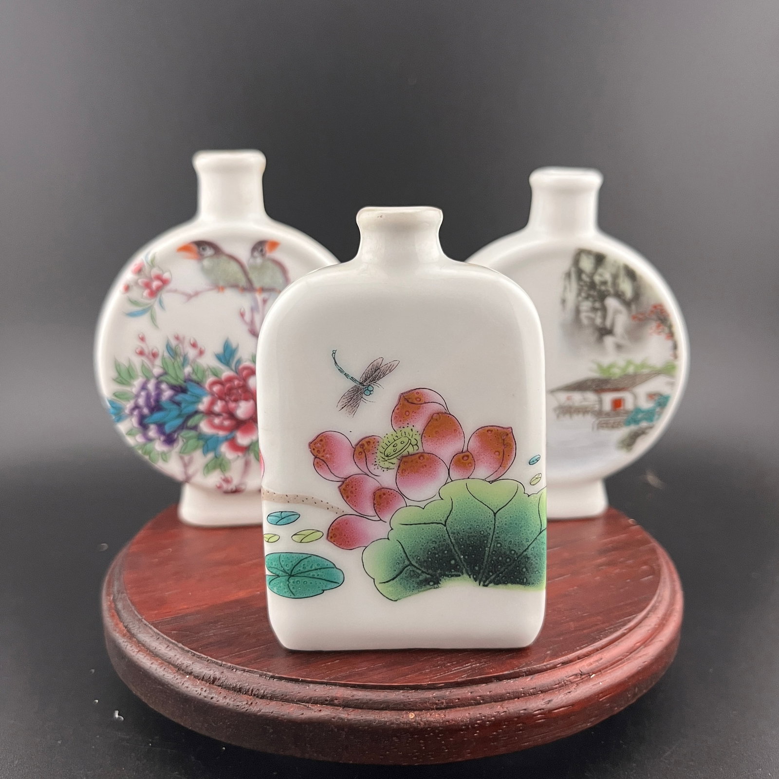 GROUP OF THREE FAMILLE ROSE PORCELAIN SNUFF BOTTLE: Modern; Long: 2.6 inch; Width: 0.84 inch; High: 3.53 inch; Long: 2.6 inch; Width: 0.74 inch; High: 3.4 inch; Long: 2 inch; Width: 0.8 inch; High: 3.1 inch. Wooden base for picture and display only.