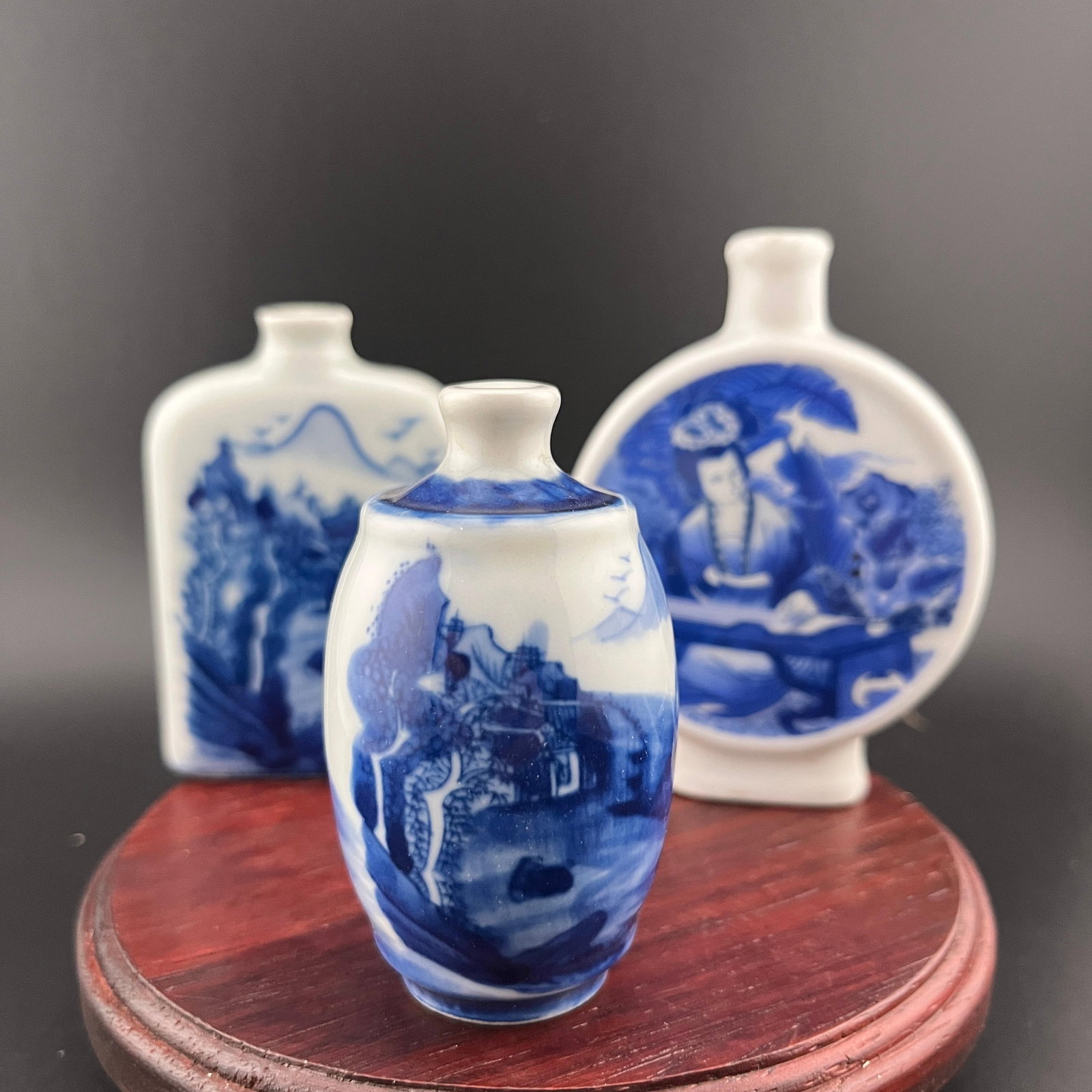 GROUP OF THREE FAMILLE ROSE PORCELAIN SNUFF BOTTLE: Modern; High: 2.8 inch; Diameter: 1.6 inch; Long: 2 inch; Width: 0.75 inch; High: 3.02 inch; Long: 2.6 inch; Width: 0.77 inch; High: 3.5 inch. Wooden base for picture and display only.