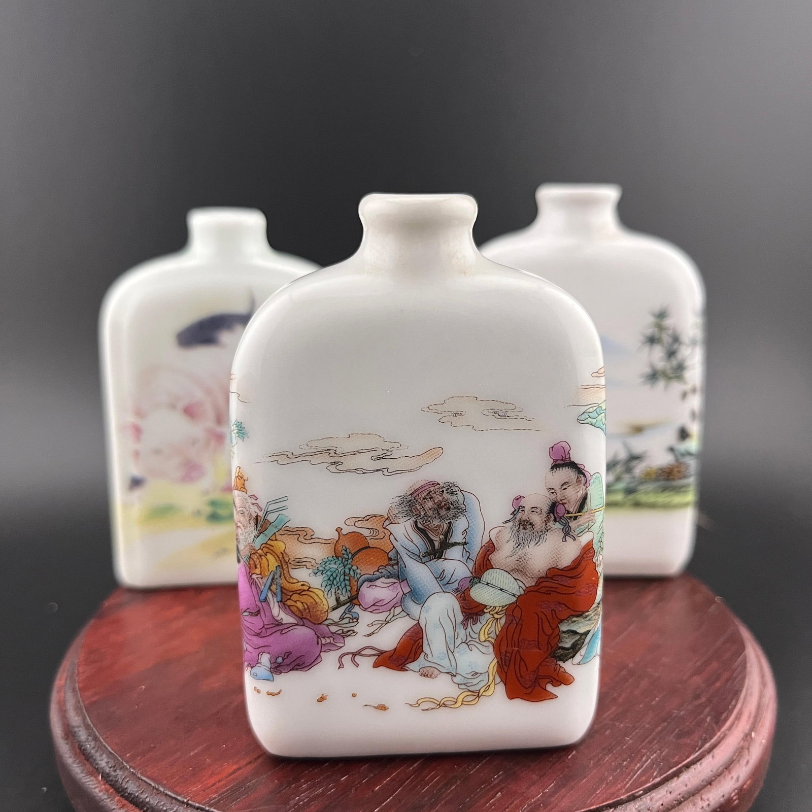 GROUP OF THREE FAMILLE ROSE PORCELAIN SNUFF BOTTLE: Modern; Long: 2.1 inch; Width: 0.84 inch; High: 3.1 inch; Long: 2.1 inch; Width: 0.84 inch; High: 3.1 inch; Long: 1.93 inch; Width: 0.7 inch; High: 2.93 inch. Wooden base for picture and display only.