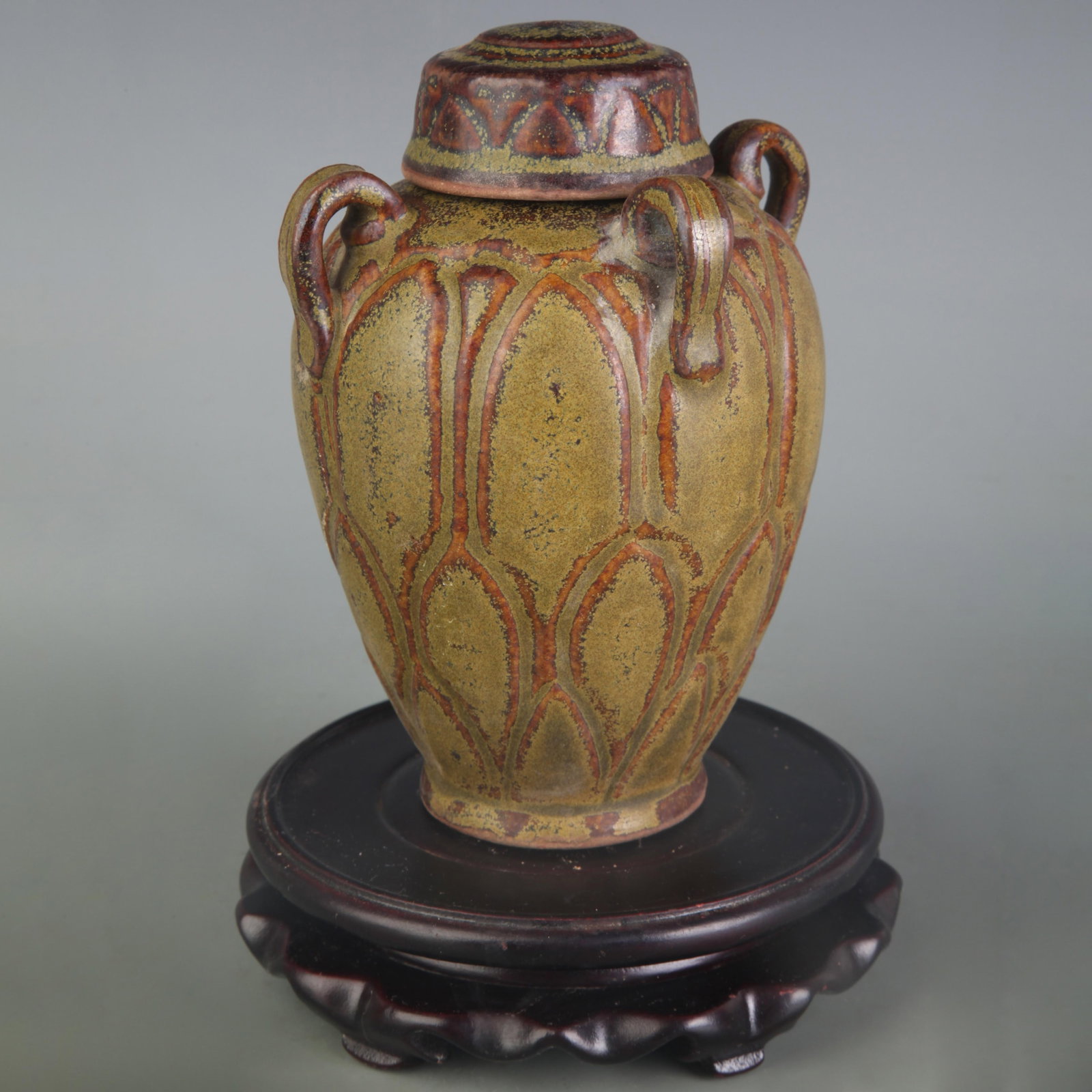 AN EEL-YELLOW GLAZED JAR WITH FOUR LOOP HANDLES: Qing Dynasty; High: 5.9 inch; Diameter: 2.2 inch; Wooden base for picture and display only.