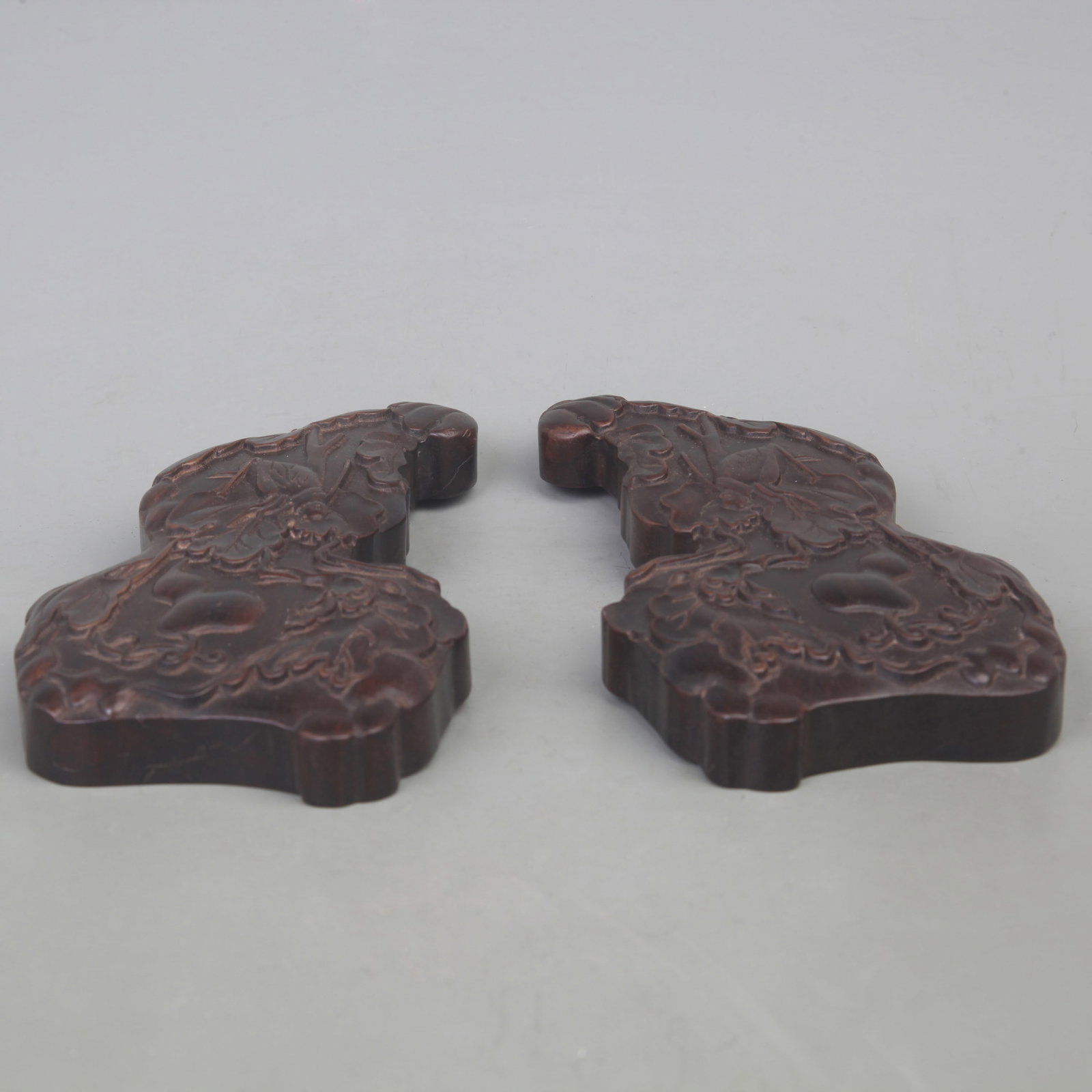 PAIR OF ANTIQUE MAHOGANY CARVED PAPERWEIGHTS WITH FU AND LU MOTIFS: Modern; Long: 7.6 inch Width: 3.7 inch High: 0.9 inch; Wooden base for picture and display only.