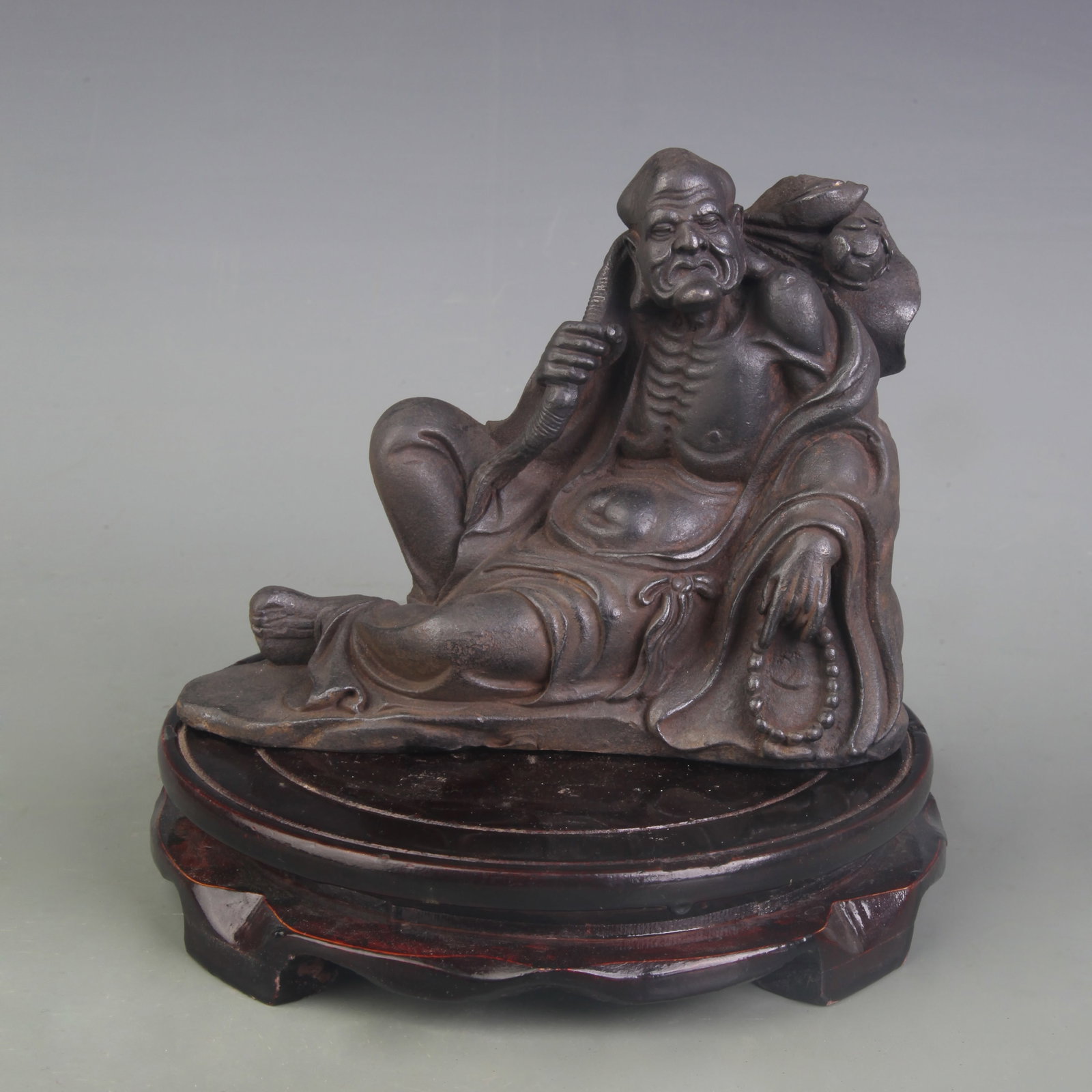 A FINE CAST IRON FIGURE OF LUOHAN: Qing Dynasty; Width: 6.3inch, High: 5.0inch; Woodbase for picture and display only