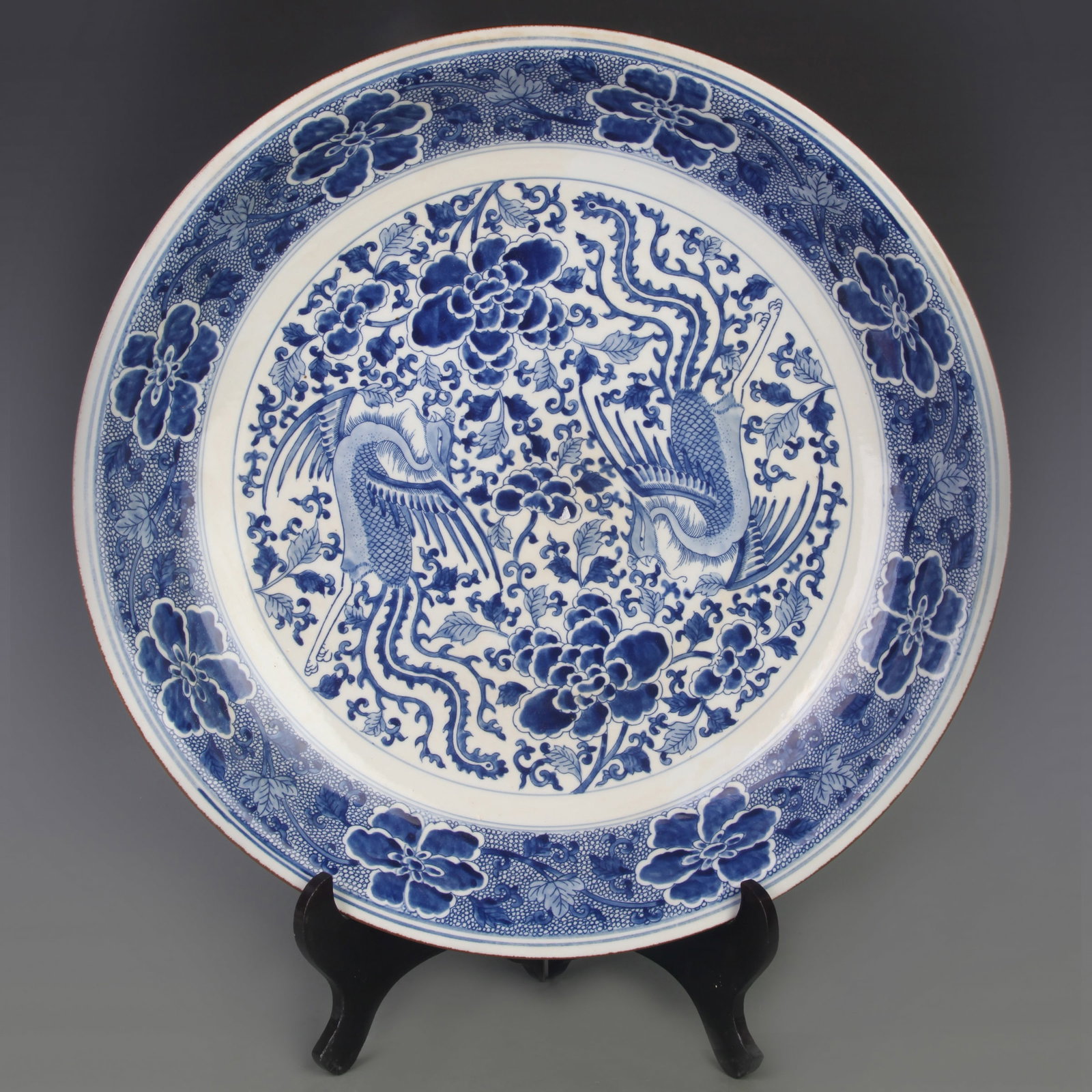 LARGE BLUE AND WHITE ‘PHOENIX AND FLORAL’ PORCELAIN DISH: Qing Dynasty Kang Xi Period; Diameter: 17.8 inch; High: 3.3 inch; Woodbase for picture and display only