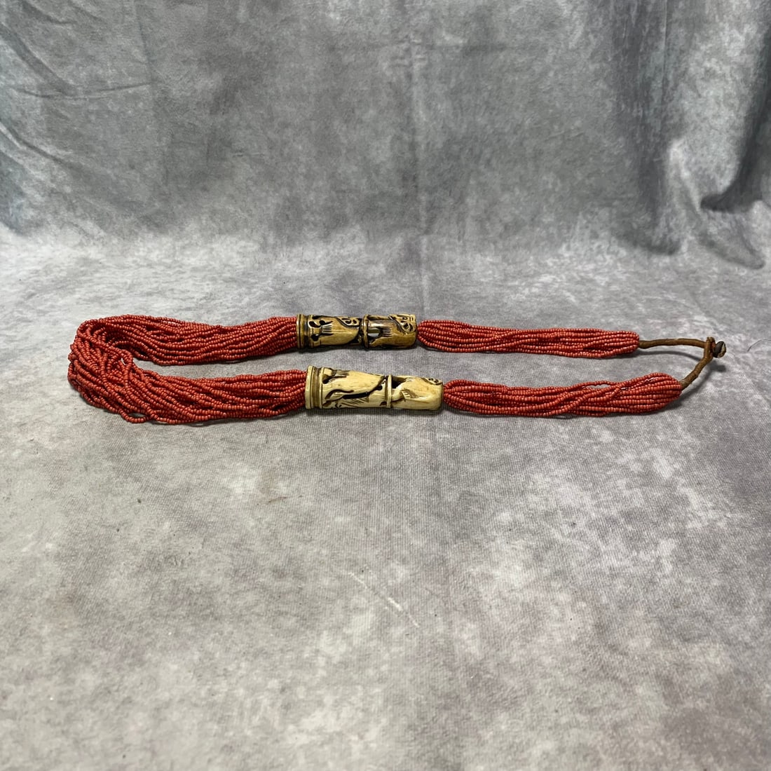 TIBETAN YAK BONE AND SMALL CORAL BRAIDED NECKLACE: 20th Century; Long: 35 inch; Woodbase for picture and display only