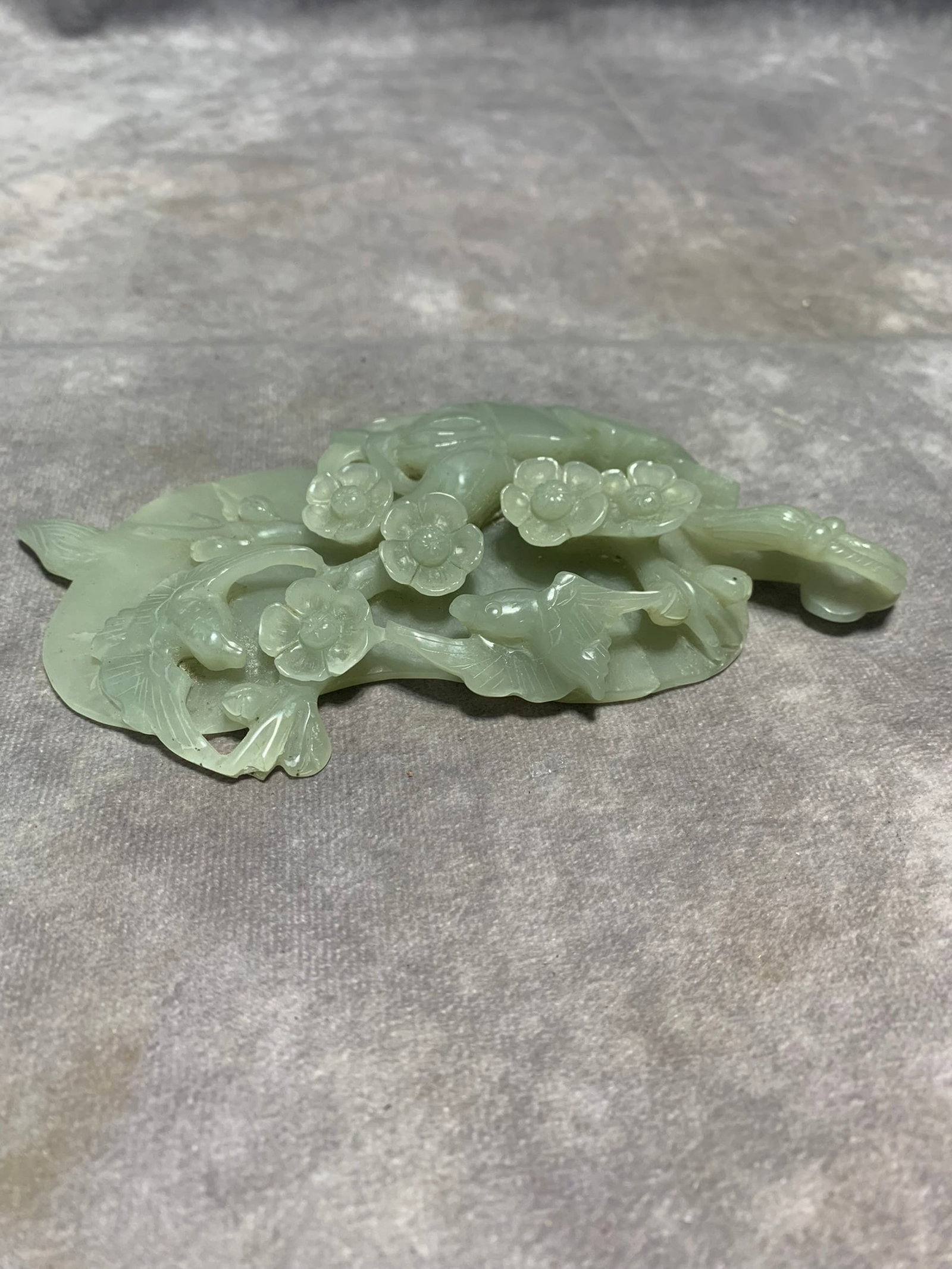 LARGE HETIAN GREENISH-WHITE JADE ORNAMENT OF BIRD AND PLUM BLOSSOM: Qing Dynasty; Long: 6.6 inch; Width: 3.9 inch; High: 0.8 inch; Woodbase for picture and display only