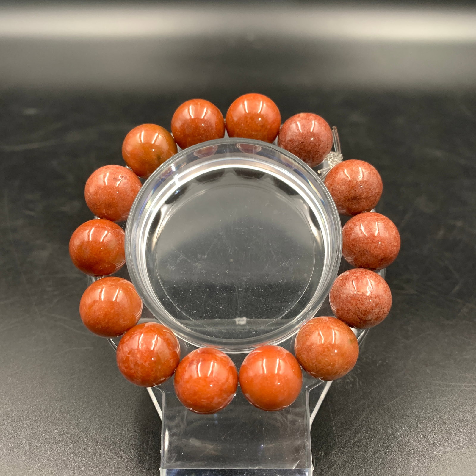 RED QUARTZ POLISHED BEAD BRACELET: Modern; Long: 3.4 inch; Diameter: 0.5 inch; Woodbase for picture and display only