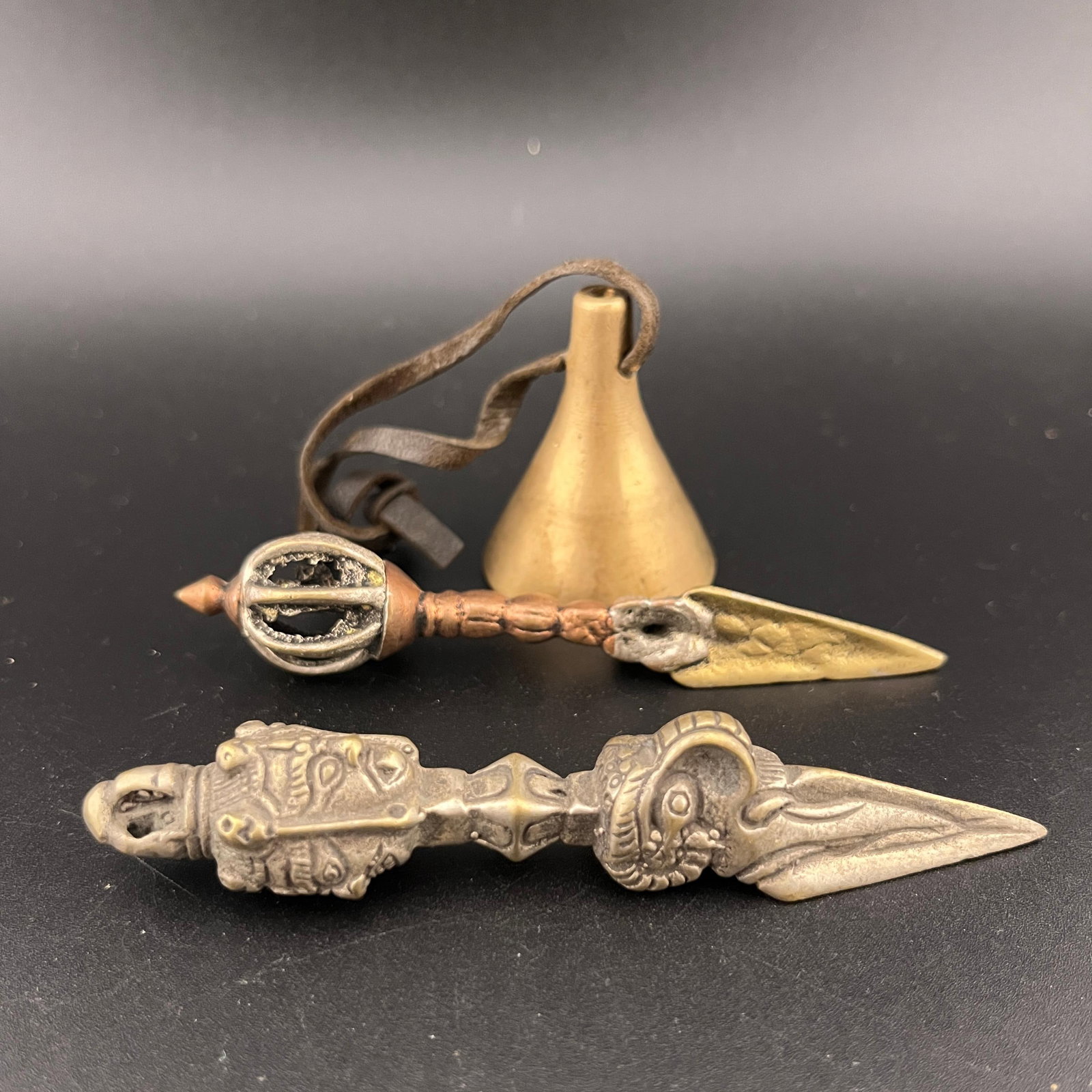 GROUP OF TWO TIBETIAN RITUAL BUDDHIST BRONZE IMPLEMENTS: 20th Century; Long: 3.7 inch; Diameter: 0.6 inch;. Long: 3.15 inch; Diameter: 0.7 inch;. High: 1.5 inch; Diameter: 1.2 inch; Woodbase for picture and display only