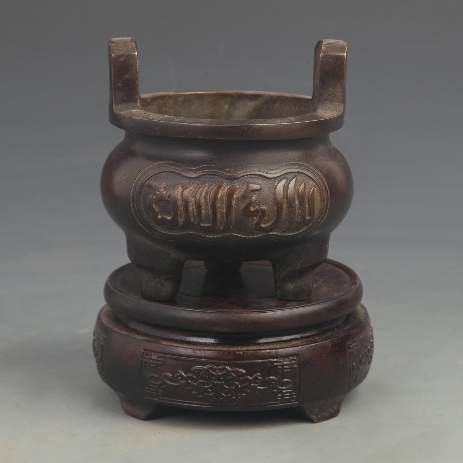 SANSKRIT PATTERN DOUBLE-HANDLED BRIDGE DING-STYLE CENSER: 19th Century; High: 4.00 inch; Diameter: 3.75 inch; Woodbase for picture and display only