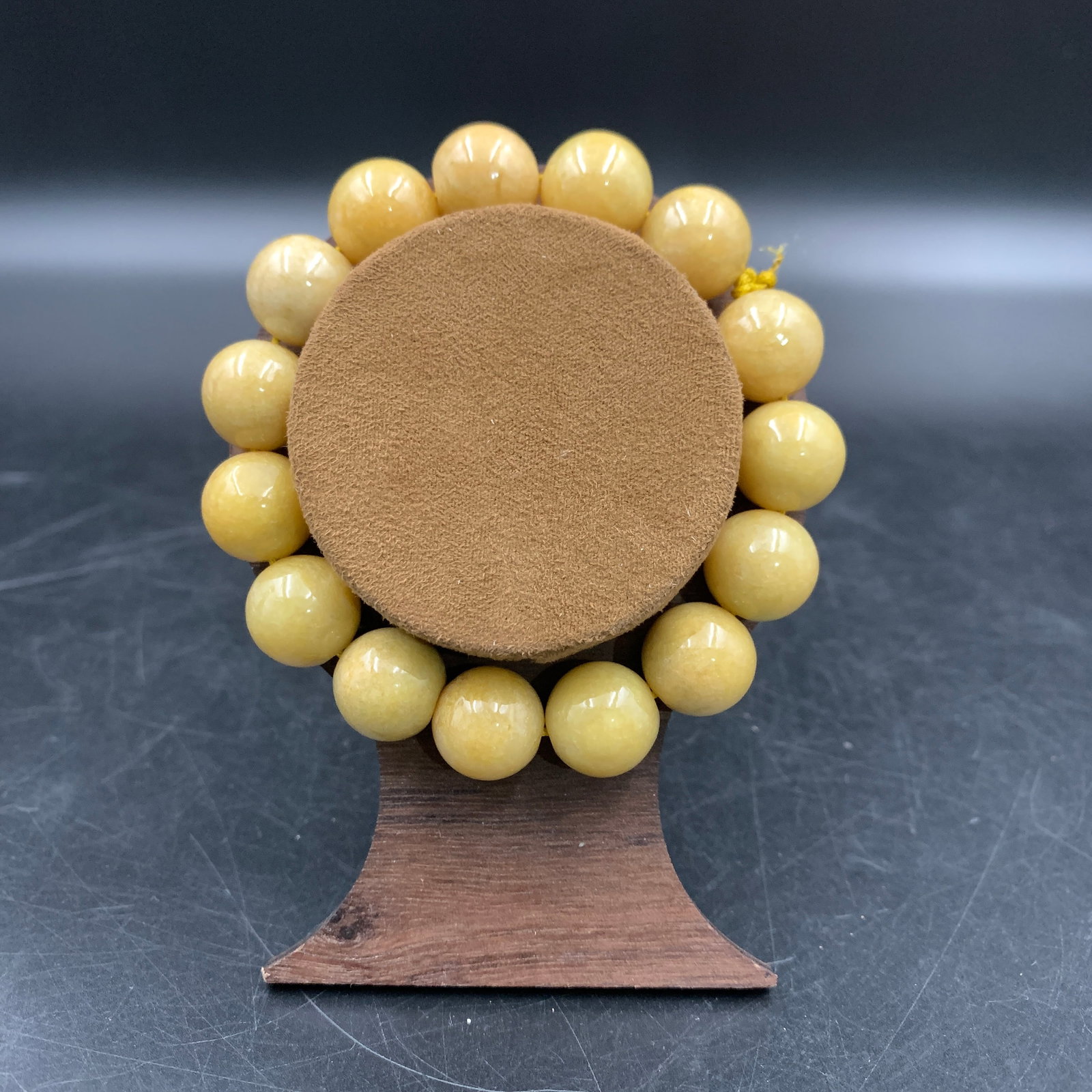 YELLOW JADE POLISHED BEAD BRACELET: Modern; Long: 3.6 inch; Diameter: 0.5 inch; Woodbase for picture and display only