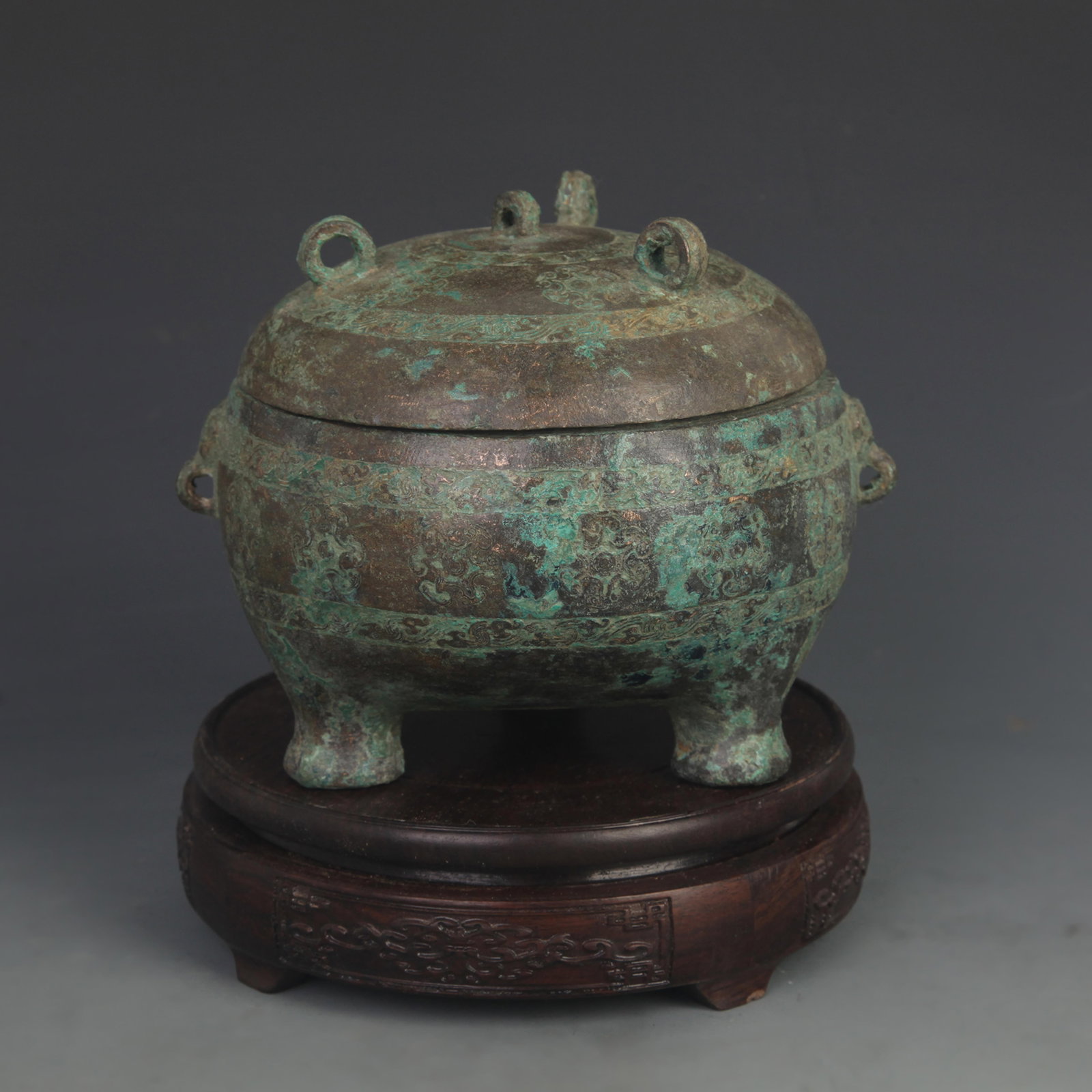 ARCHAISTIC BRONZE TRIPOD DING WITH RING HANDLES AND FLORAL MEDALLION KNOPS: Han Dynasty Style; High: 5.25 inch; Diameter: 4.75 inch; Woodbase for picture and display only