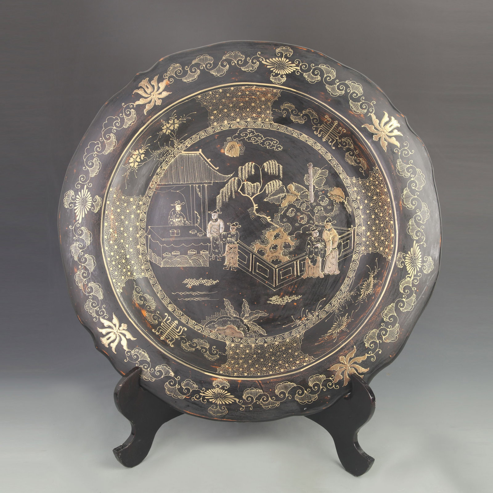 LACQUER AND GOLD-PAINTED LARGE PLATE WITH STORIES AND LOTUS PATTERN: Qing Dynasty; High: 1.50 inch; Diameter: 20.25 inch; Woodbase for picture and display only