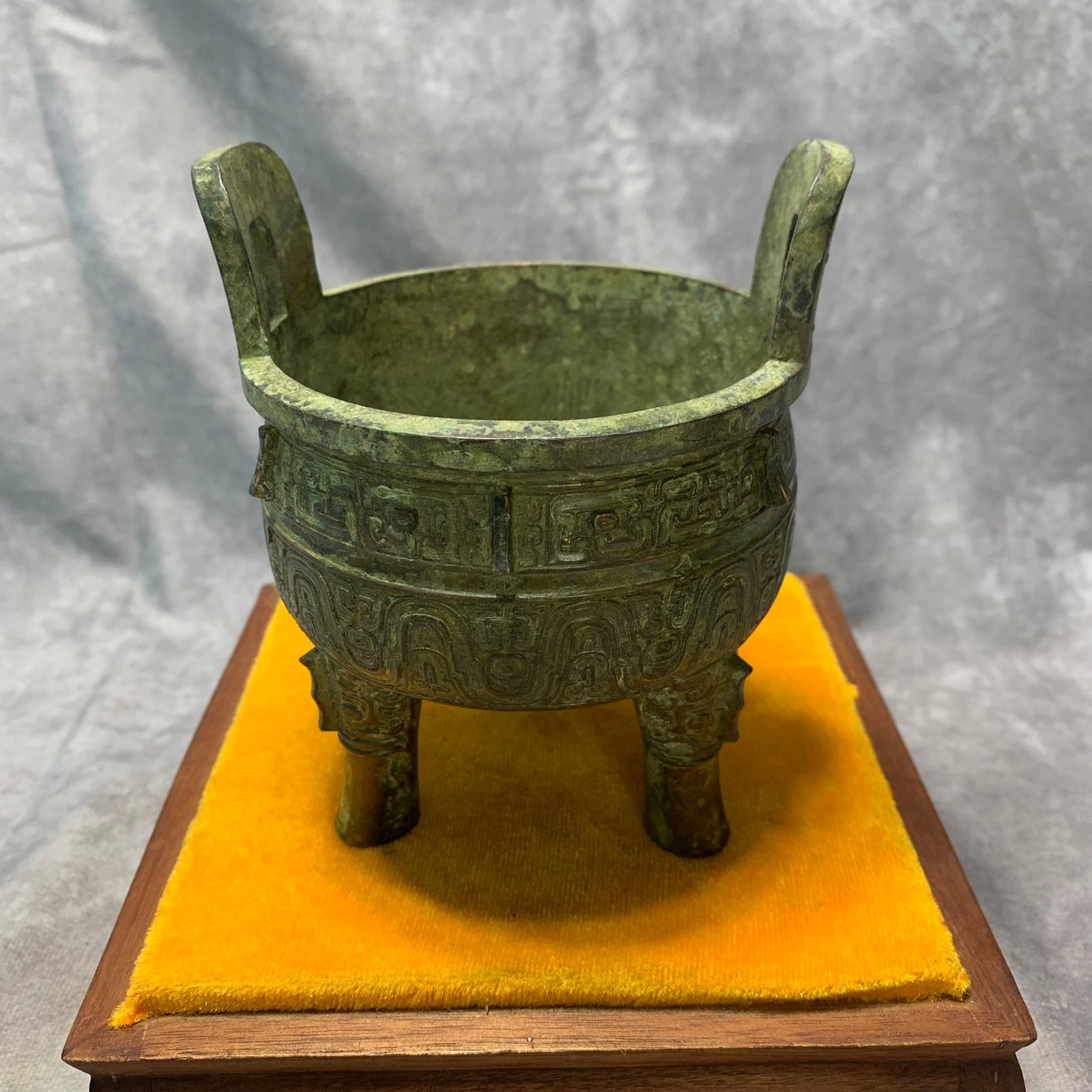 BRONZE TRIPOD CENSER WITH BEAST FEET, TAOTIE DECORATION, AND UPRIGHT HANDLES, "XUAN" MARK: Ming Dynasty Style; High: 5.2 inch; Diameter: 4.1 inch. Wooden base for display only