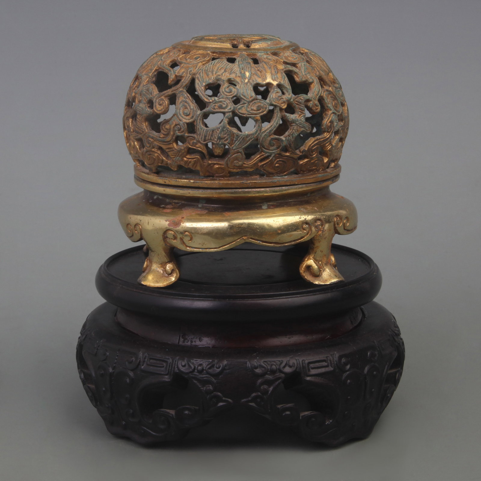 A BRONZE AUSPICIOUS PATTERN FOUR-LEGGED INCENSE BURNER: Qing Dynasty; Diameter: 4.5 inch; High: 3.6 inch; . Wooden base for display only