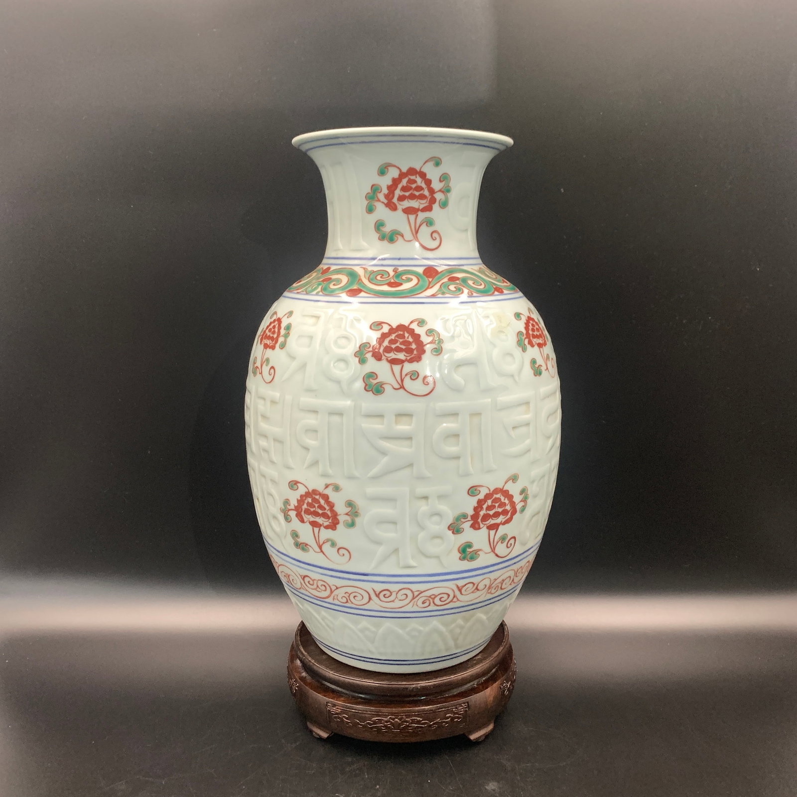 CELADON RAISED SANSKRIT-CHARACTER PORCELAIN VASE: Qing Dynasty; High: 13.9 inch; Diameter: 8.7 inch; . Wooden base for display only