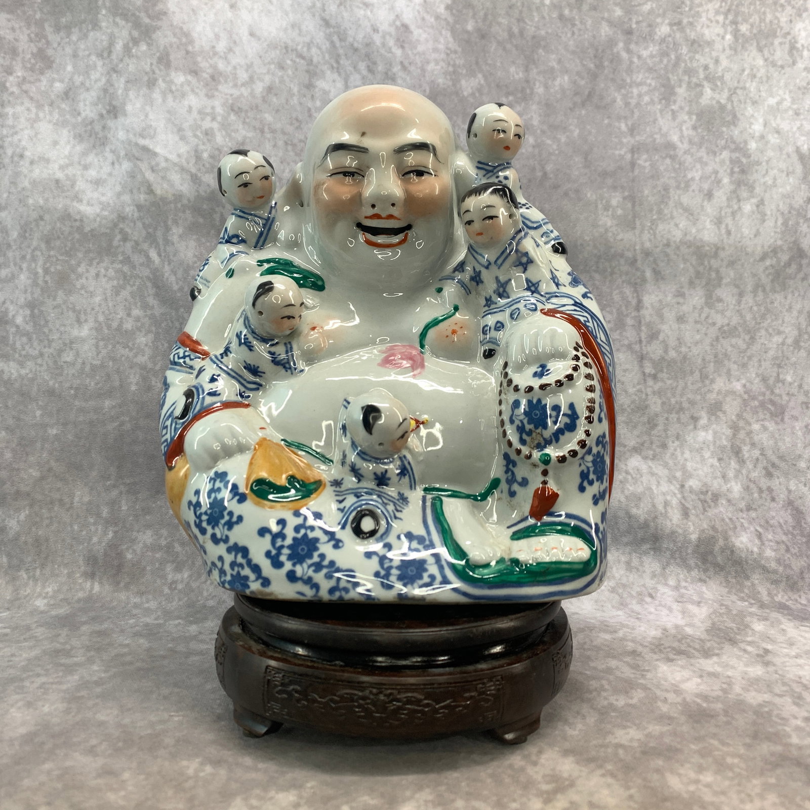 PORCELAIN "FIVE CHILDREN" LAUGHING BUDDHA (BUDAI) STATUE: Modern; Long: 8.7 inch; Width: 5.5 inch; High: 9.5 inch; . Wooden base for display only