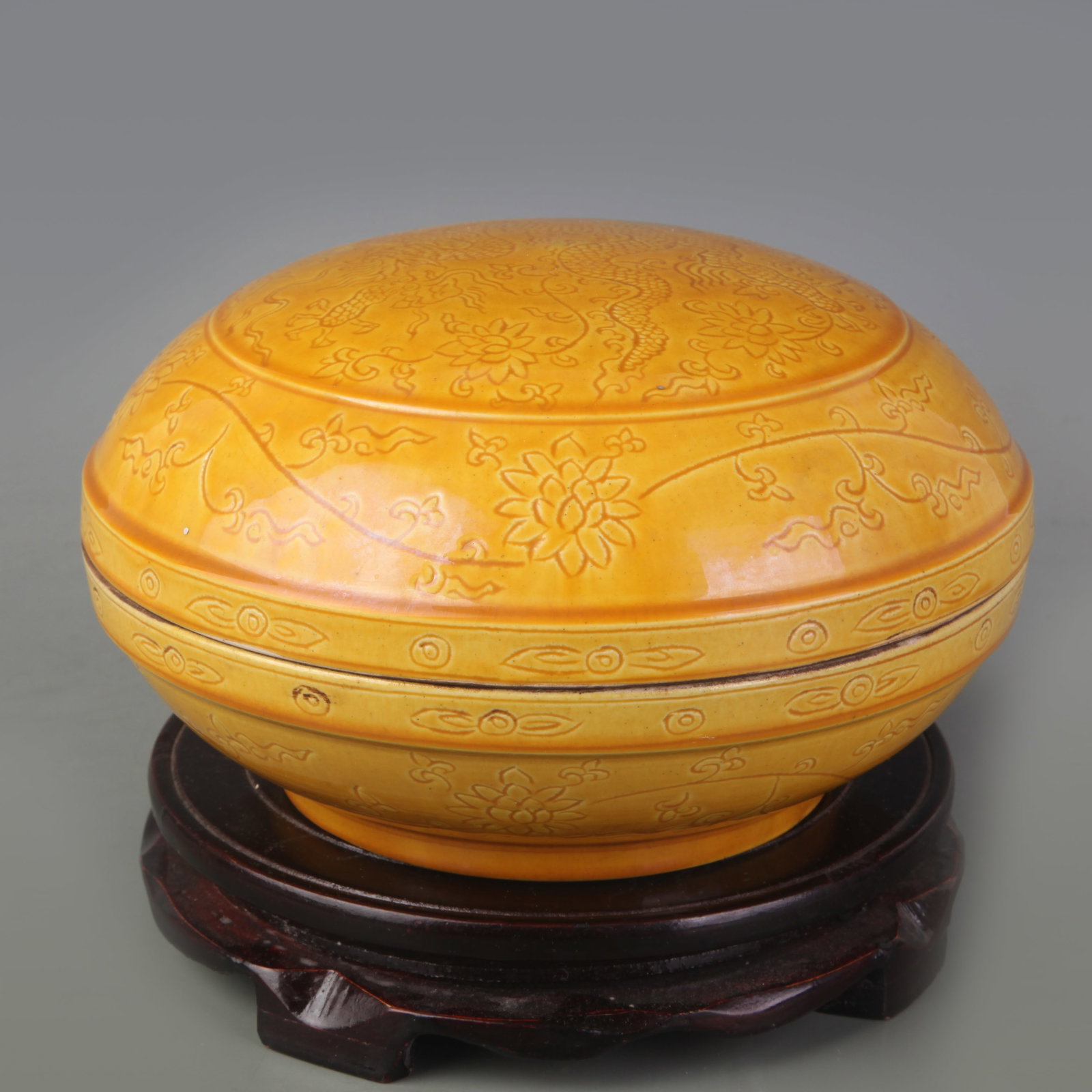 YELLOW GLAZED COVERED BOWL WITH INCISED DRAGON PATTERN: Ming Dynasty Hong Zhi Period; Diameter: 7.1 inch; High: 4.4 inch. Wooden base for display only